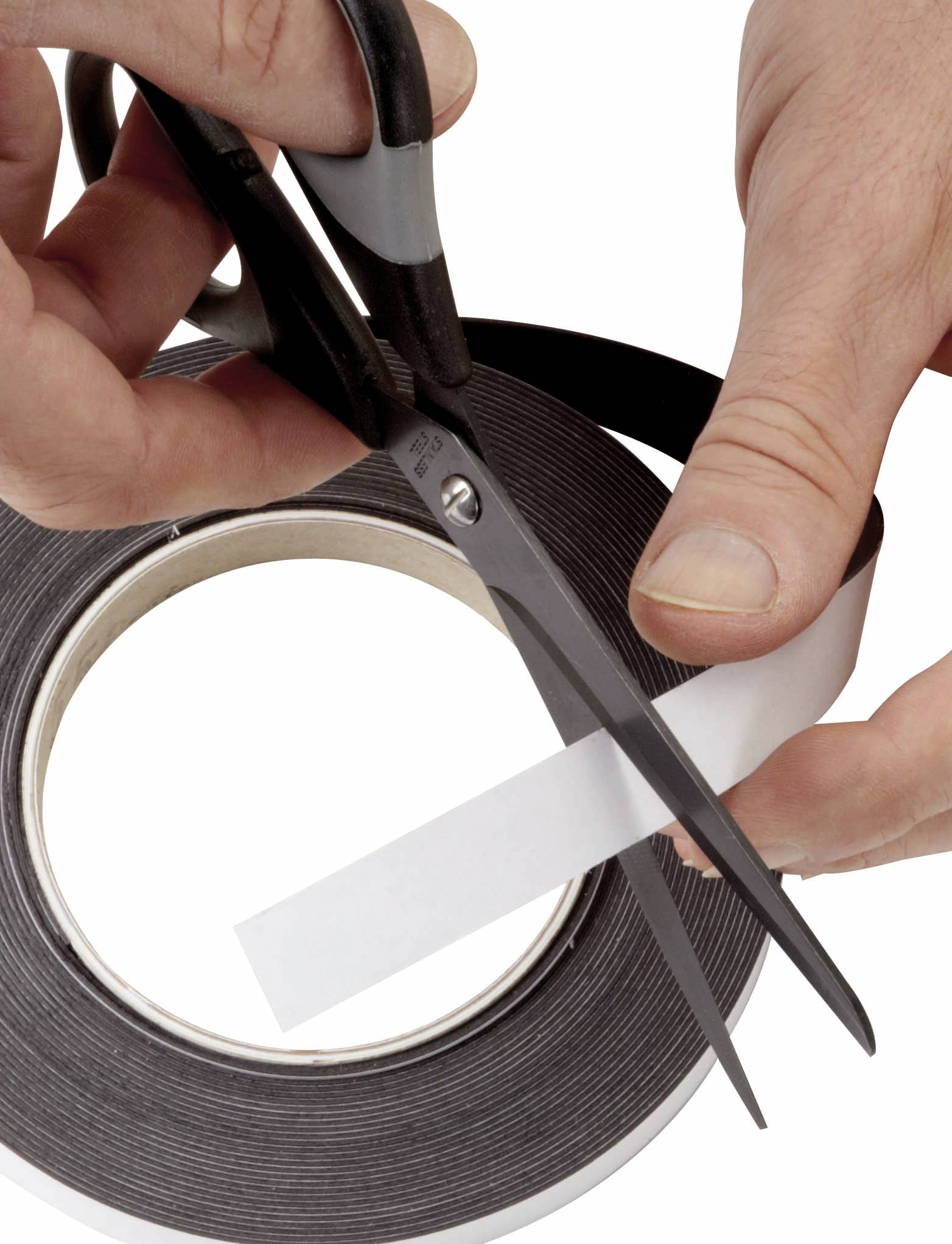 Eine Person schneidet mit einer Schere ein Stück Klebeband von einer Rolle ab.