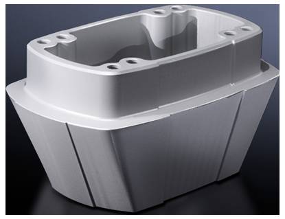 Grauer, rechteckiger Metallblock mit abgerundeten Ecken und Bohrlöchern an der Oberseite, auf dunklem Hintergrund.