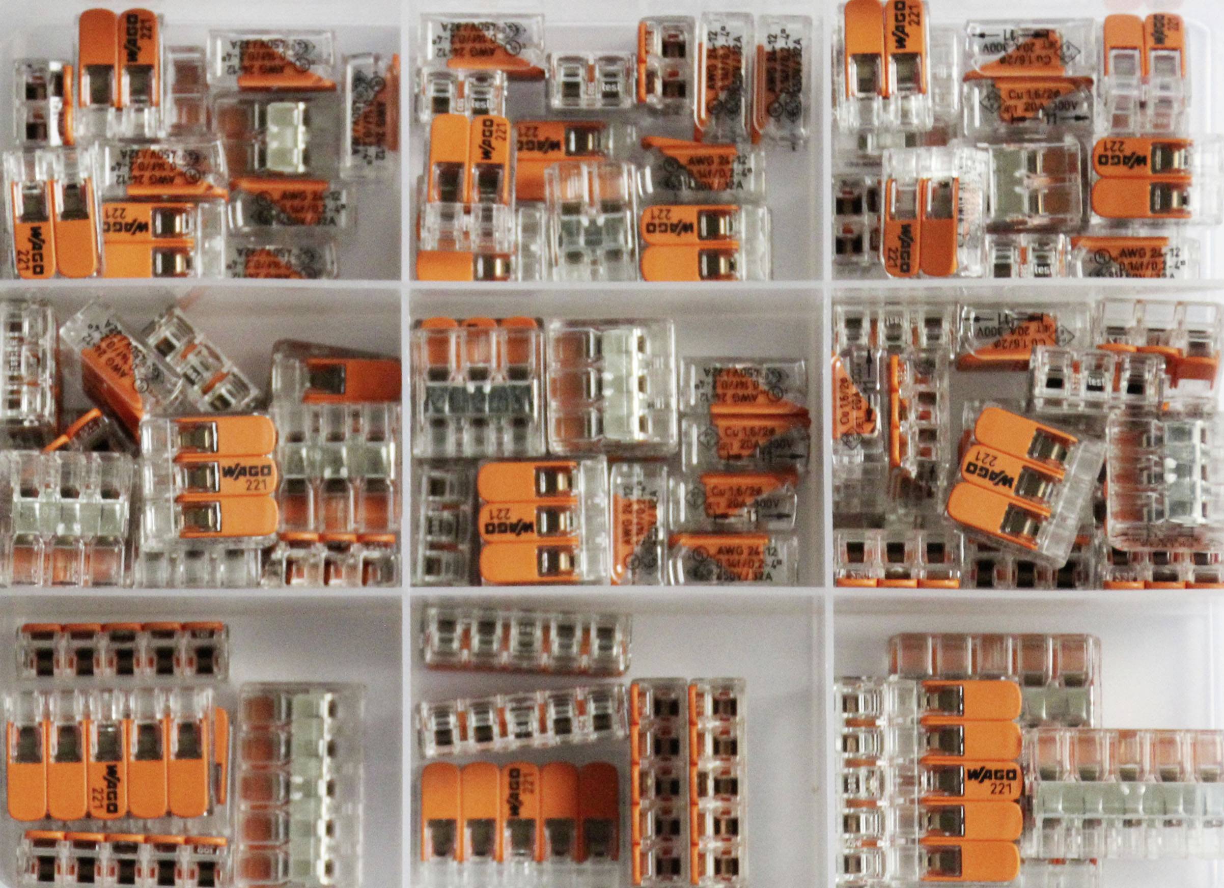 Transparentes Behältnis mit sortierten WAGO-Klemmen in verschiedenen Größen und Formen für elektrische Verdrahtung.