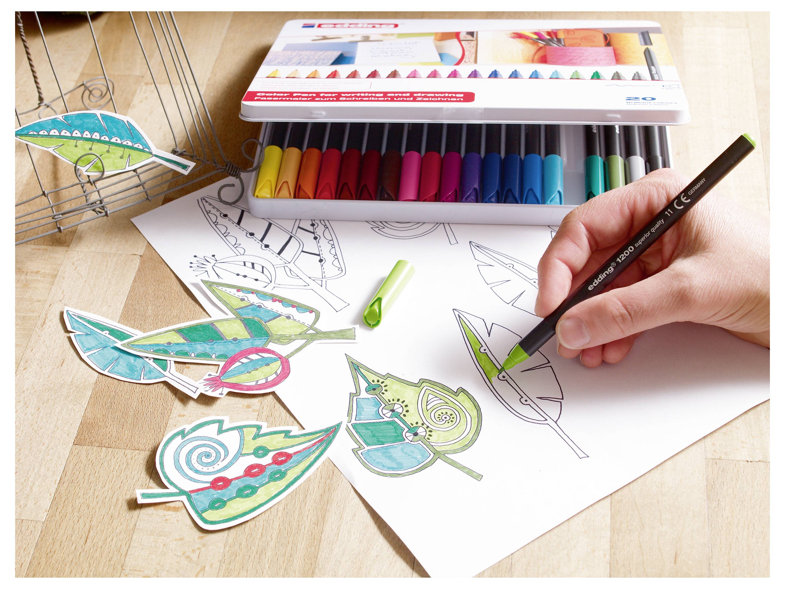 Handzeichnungen und Färbung von blattförmigen Designs auf Papier mit Farbmarkern, mit fertigen dekorativen Papierblättern neben der Skizze.