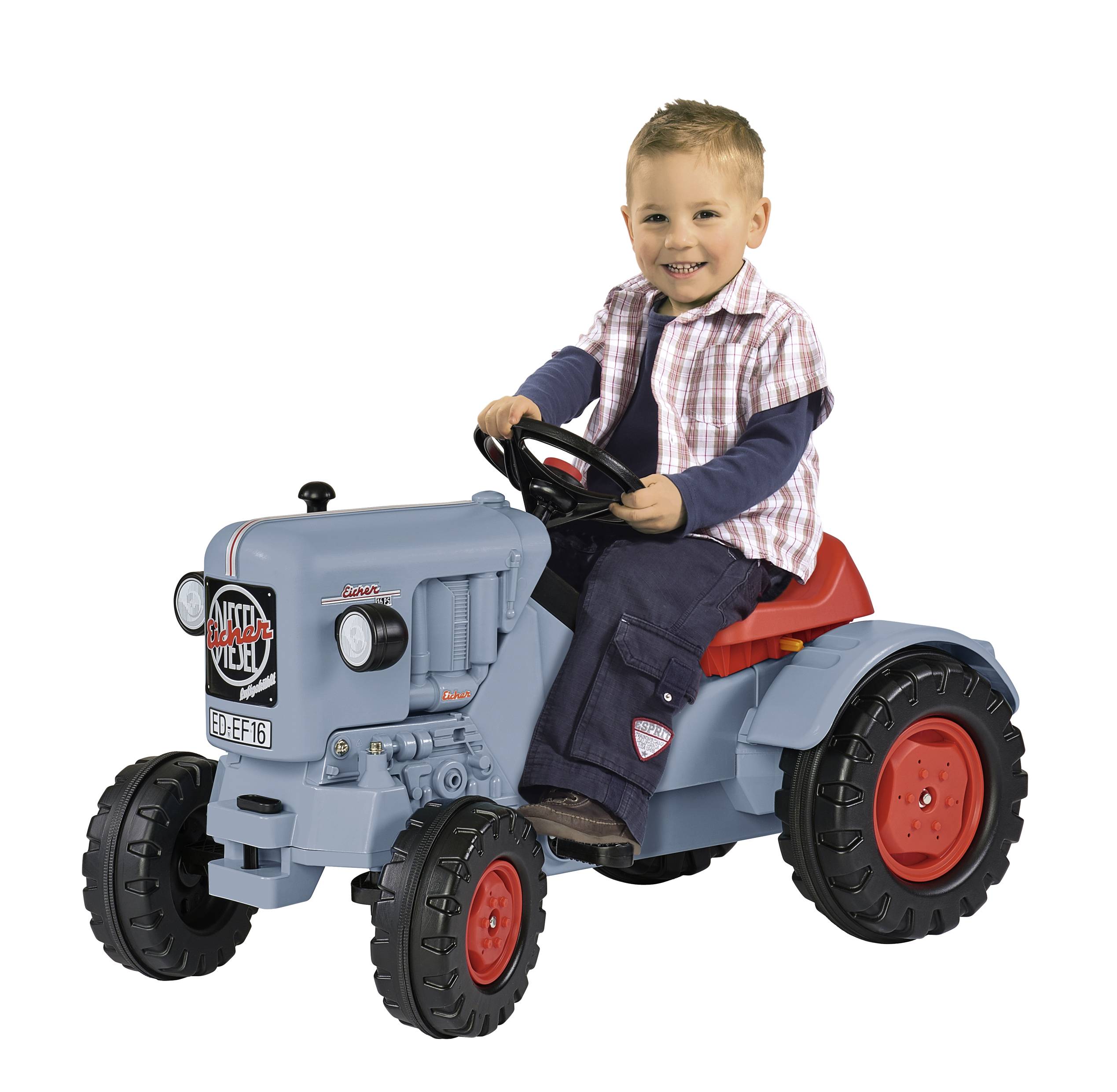 Ein Kind sitzt lächelnd auf einem blauen Spielzeugtraktor mit roten Rädern. Es trägt ein kariertes Hemd und eine dunkle Hose.