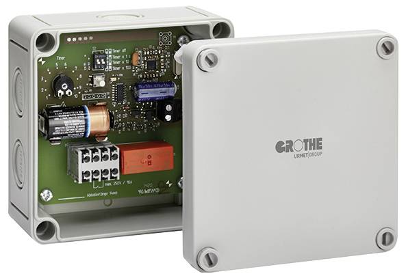 Offene graue Elektrosteuerkiste mit entfernter Frontabdeckung, die eine Leiterplatte, eine Batterie, ein Relais und Verdrahtungsklemmen im Inneren zeigt.