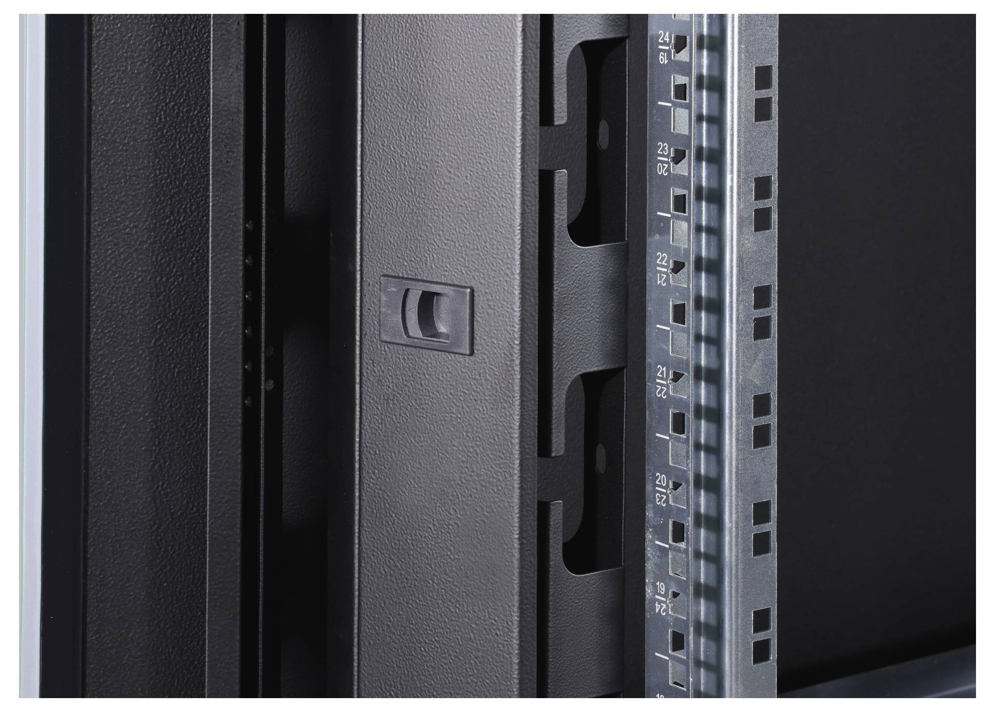 Ein schwarzes Metallscharnier an einem Graustufen-Rack mit numerierter Skala auf der rechten Seite.