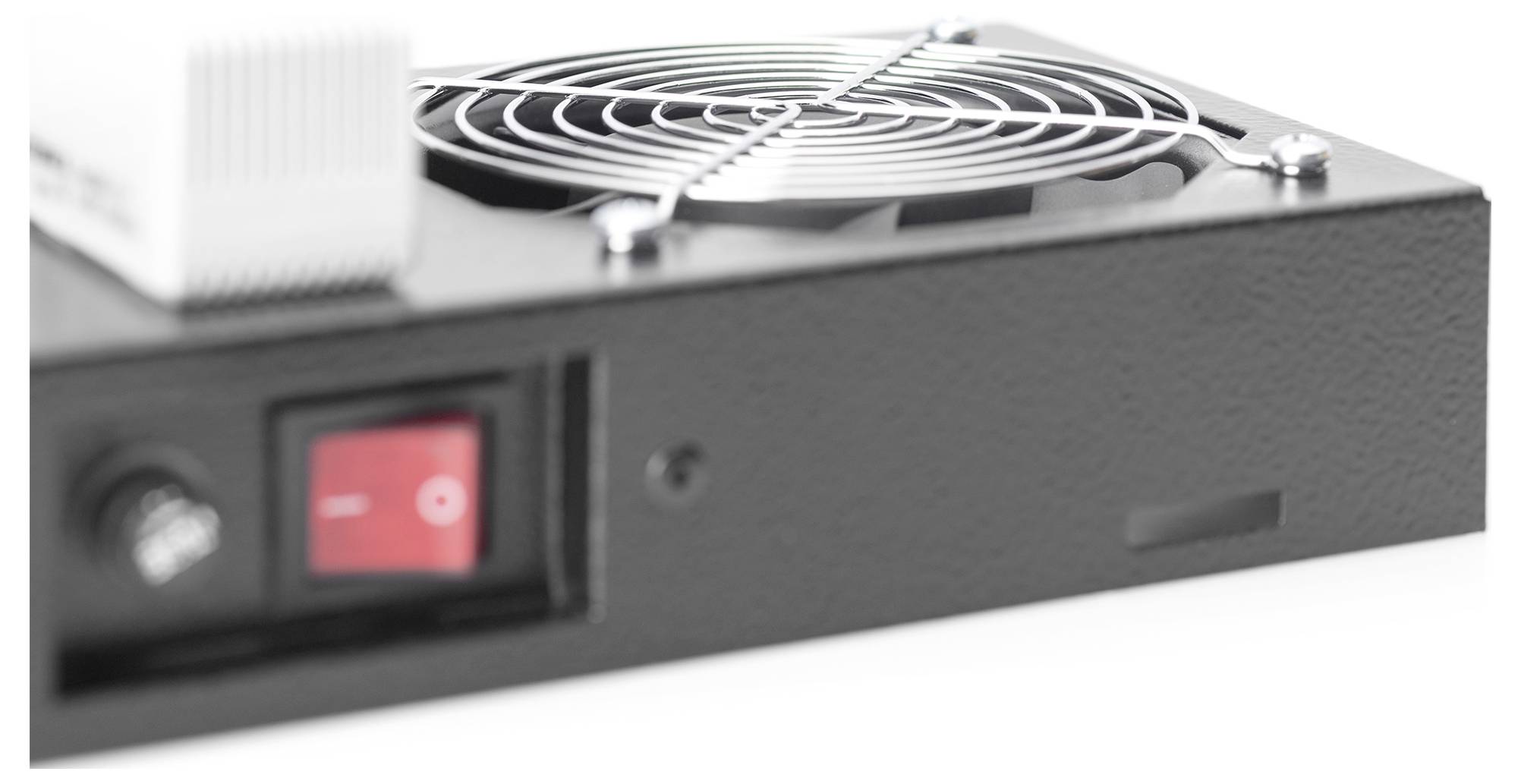 Eine Nahaufnahme eines schwarzen elektronischen Geräts, die einen roten Netzschalter und einen runden Kühlüfter mit einem schützenden Metallgitter hervorhebt.