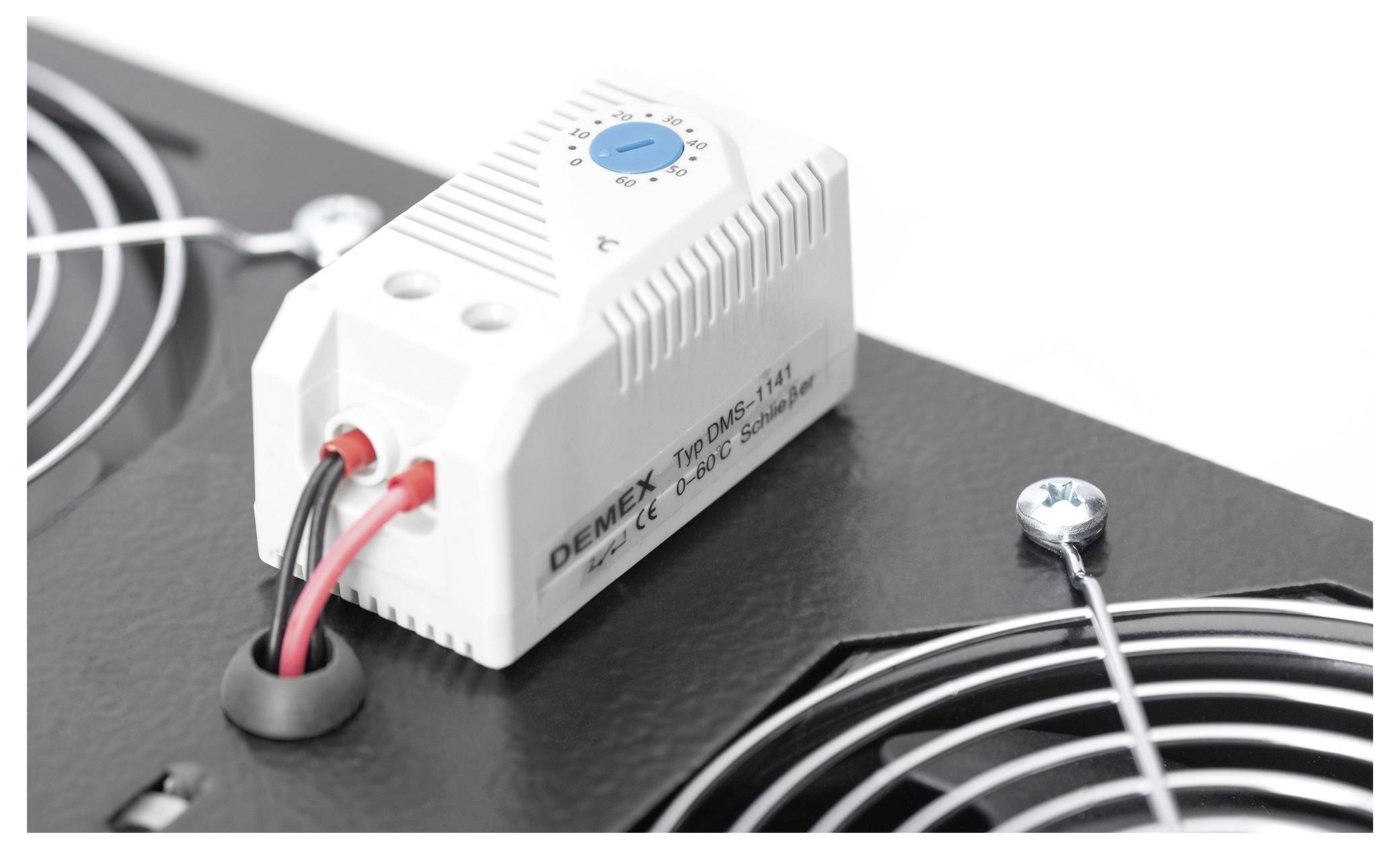 Thermostat mit Drehregler und Verkabelung, montiert auf schwarzem Gehäuse mit Lüftungsgittern.