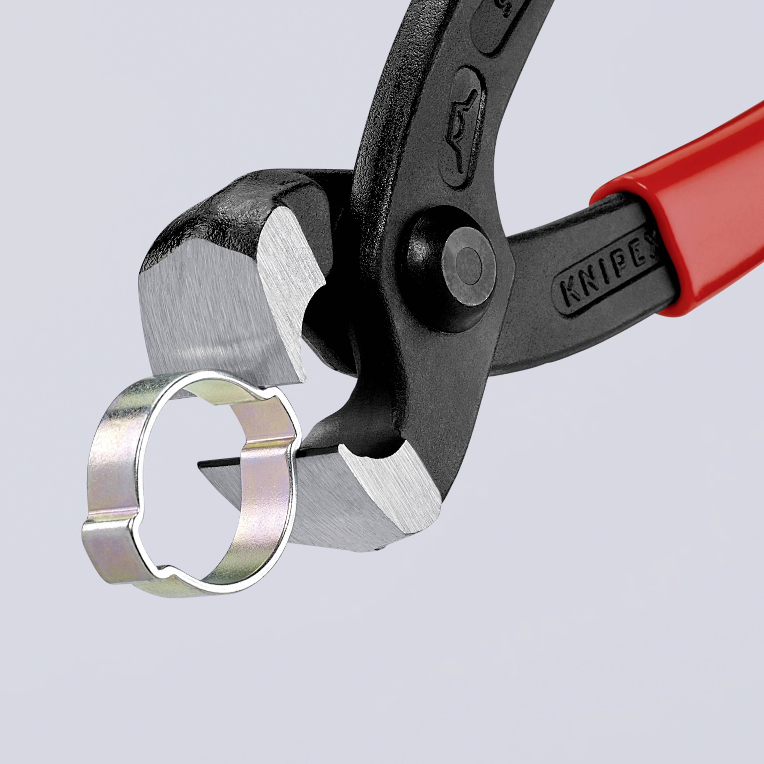 Zange mit rotem Griff hält einen silbernen Ring.