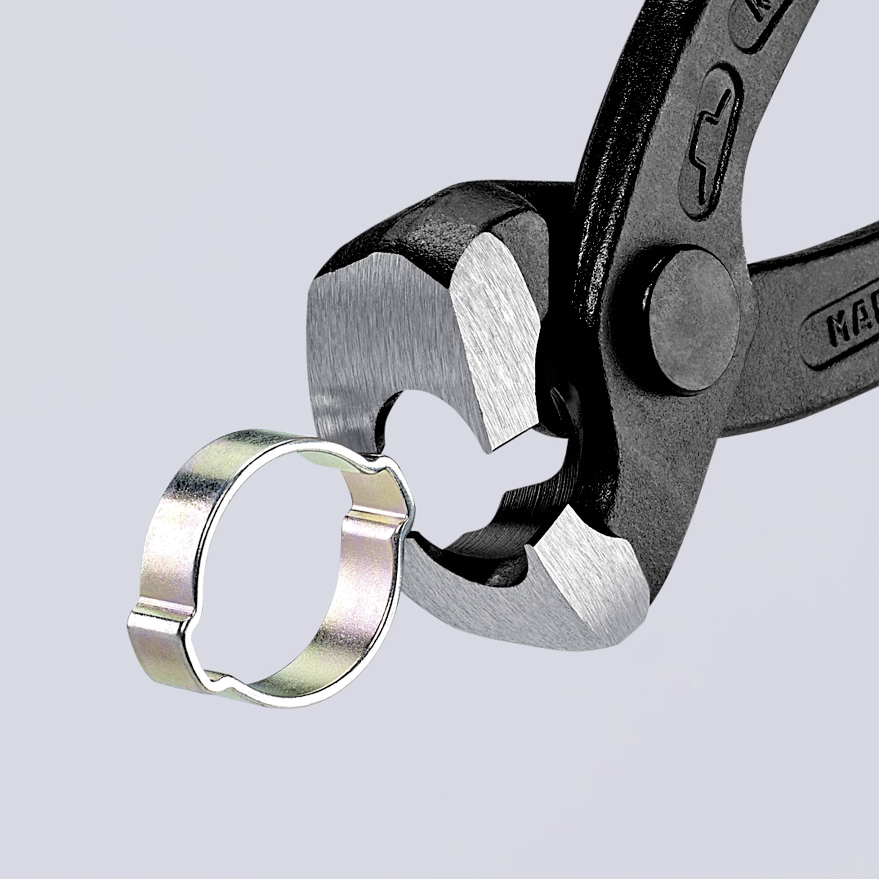 Eine schwarze Zange entfernt eine Metallklammer. Die Zange ist aus Metall mit schwarzer Beschichtung, die Klammer ist rund.