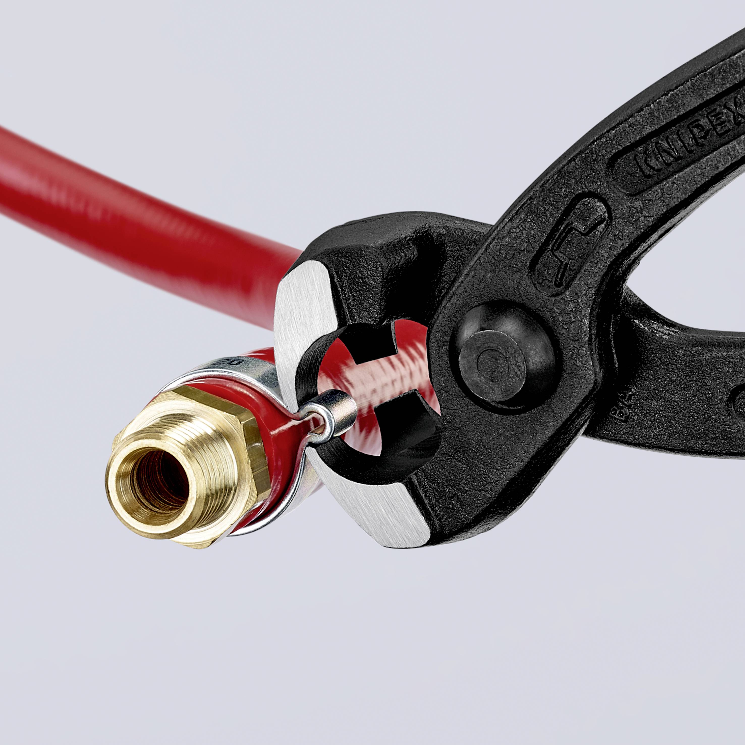 Ein rotes Kabel wird mit einer Zange fest an einem goldenen, metallischen Stecker gehalten, der zur Verbindung dient.