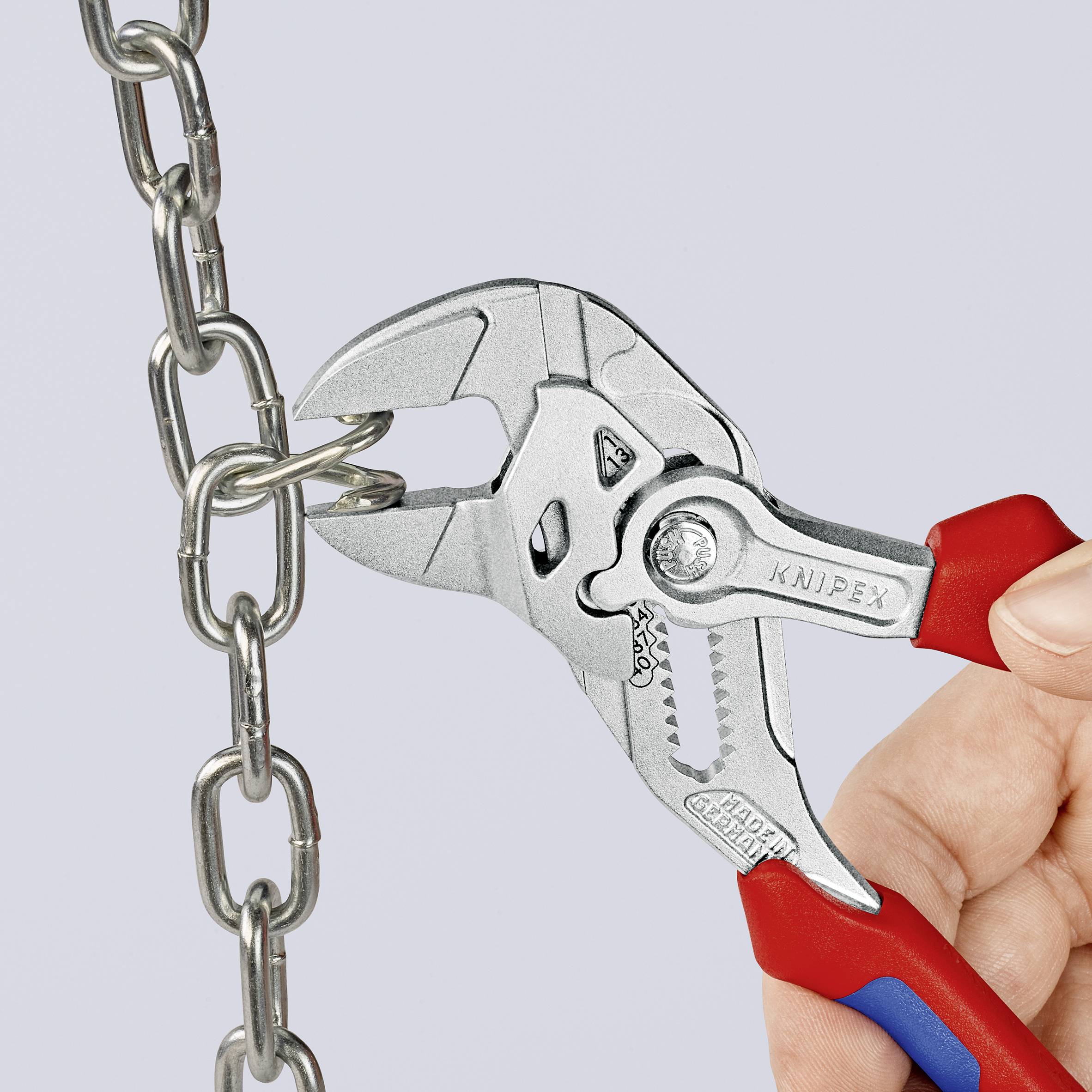 Hand hält eine Kombizange, die eine Metallkette greift.