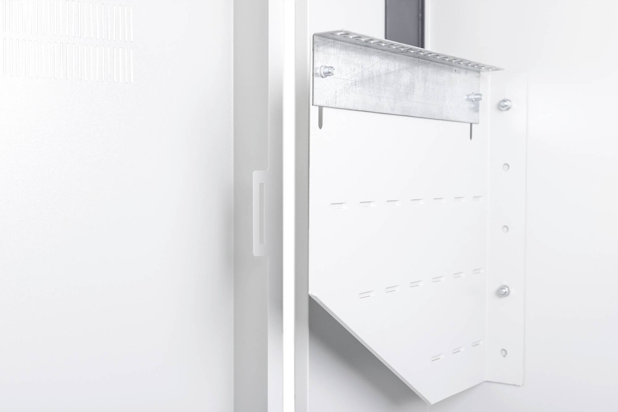 Eine weiße Metallhalterung an einer Wand, die zur Unterstützung von Geräten oder Installationen dient, befestigt mit Schrauben.