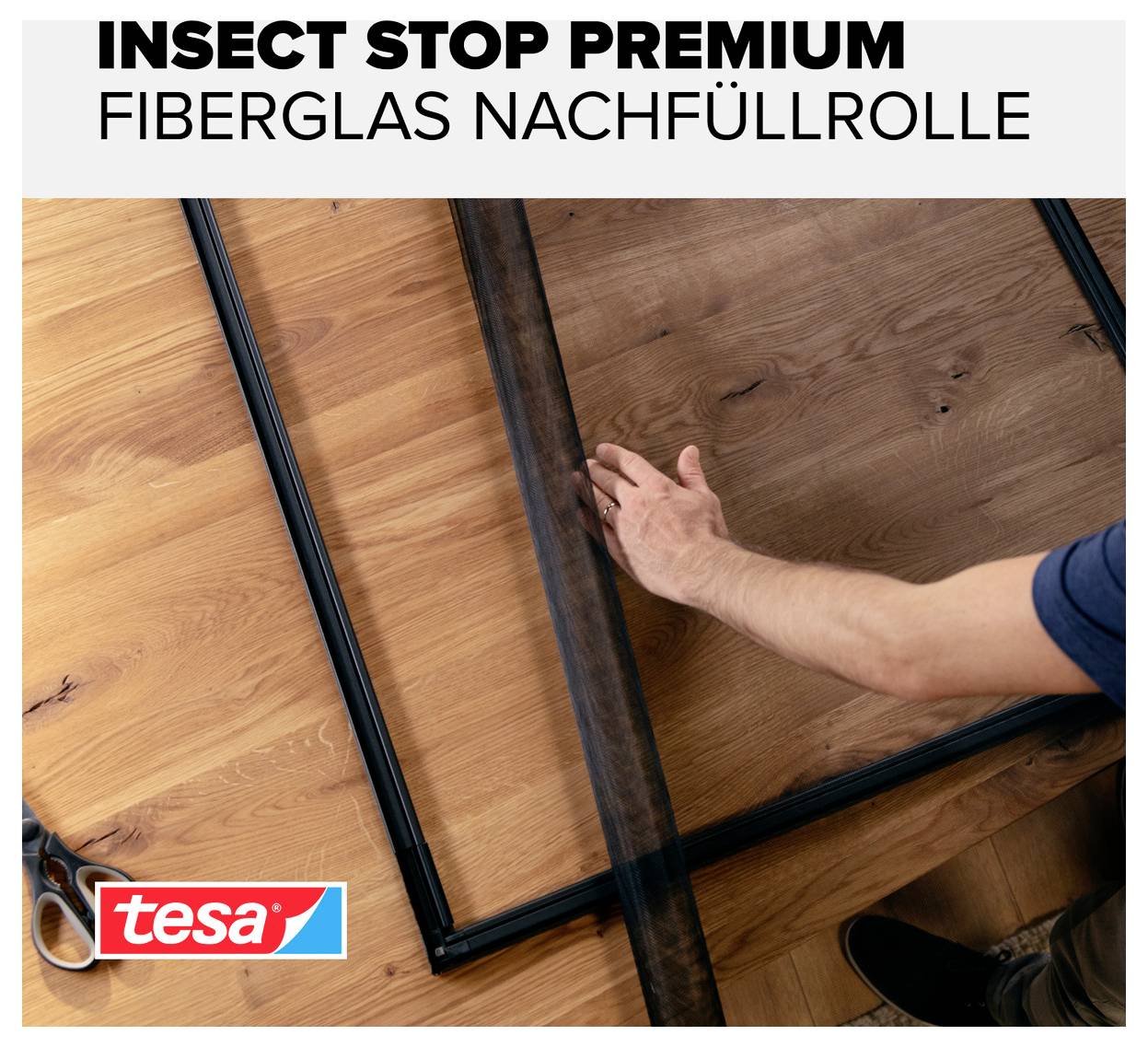 Person spannt ein schwarzes Insektenschutz-Fiberglasgewebe in einen Fensterrahmen; Text: 'INSECT STOP PREMIUM FIBERGLAS NACHFÜLLROLLE', tesa-Logo.