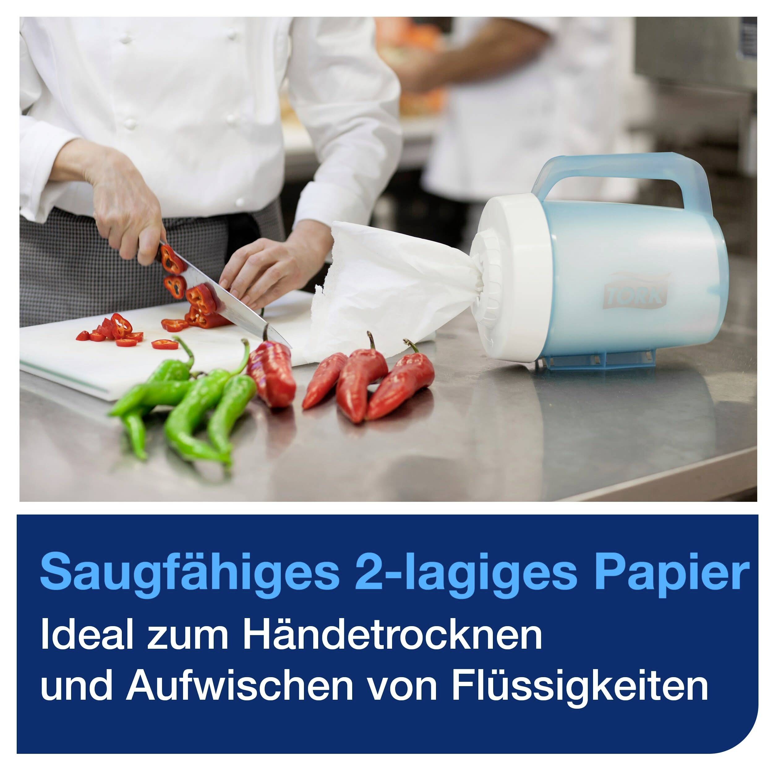 Eine Person schneidet rote Paprika. Auf einem Tisch liegt Küchenpapier, beschriftet mit 'Saugfähiges 2-lagiges Papier'.