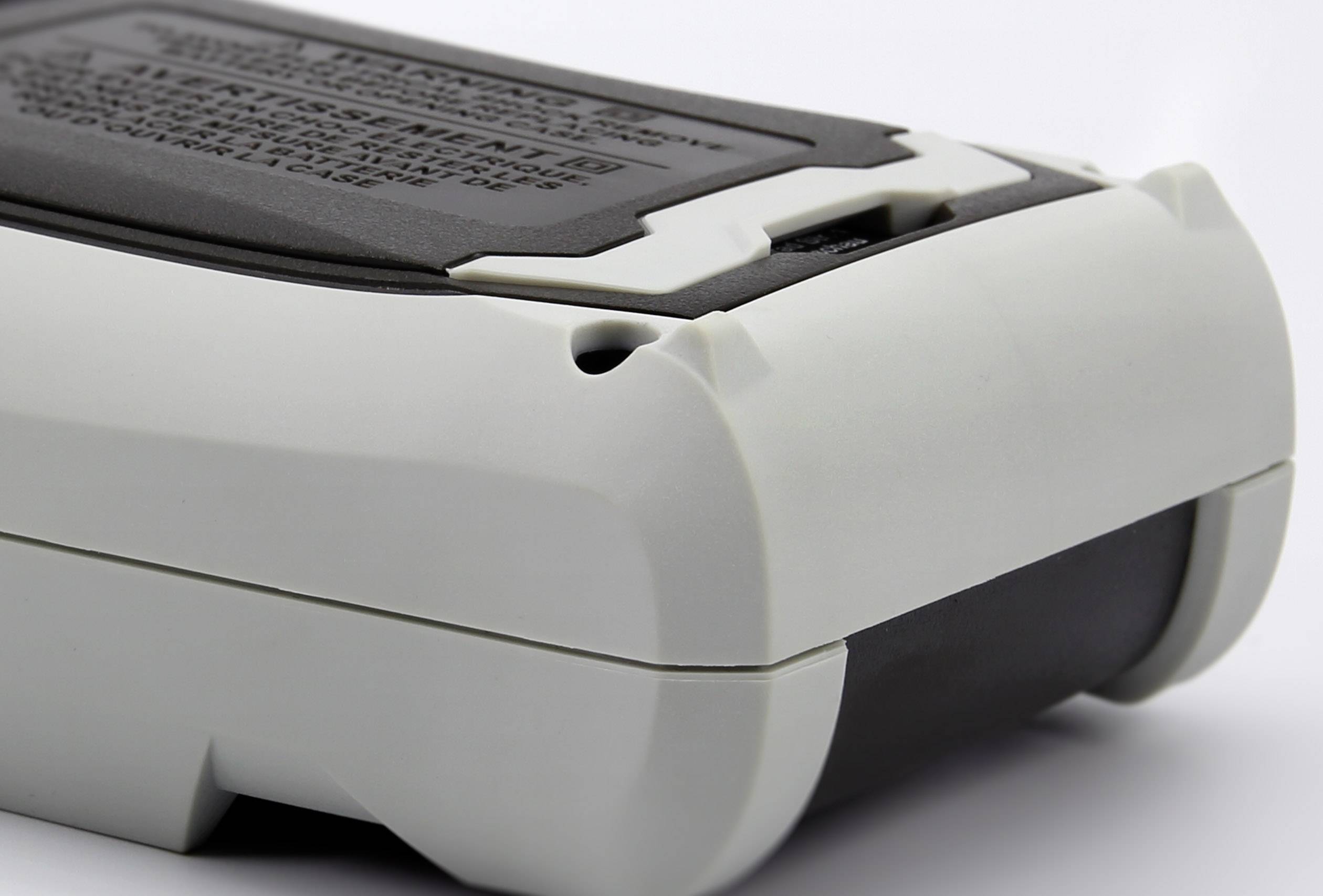 Mobilgerät aus weißem und schwarzem Kunststoff, vermutlich ein elektronisches Messgerät, gezeigt von der Rückseite.