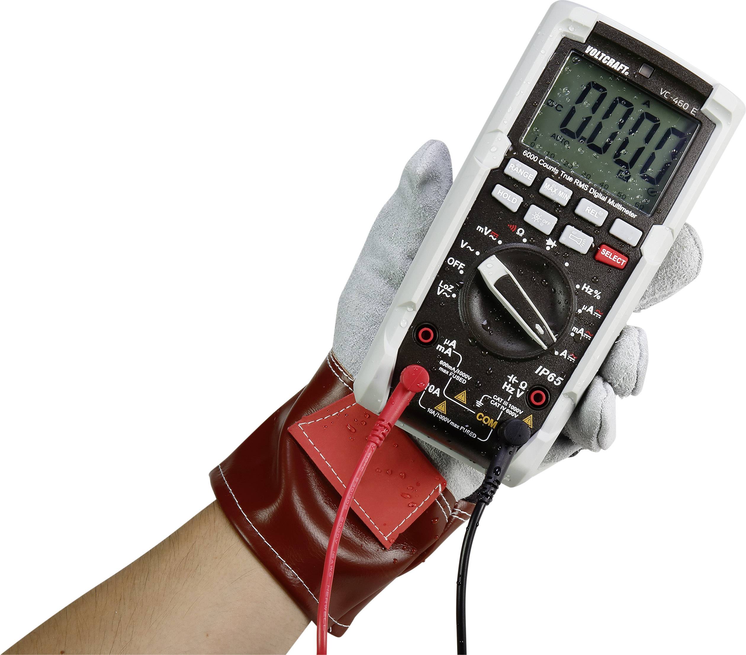 Hand mit Schutzhandschuh hält ein Multimeter mit ablesbarem Display, das Null anzeigt. Rote und schwarze Messleitungen sind angeschlossen.