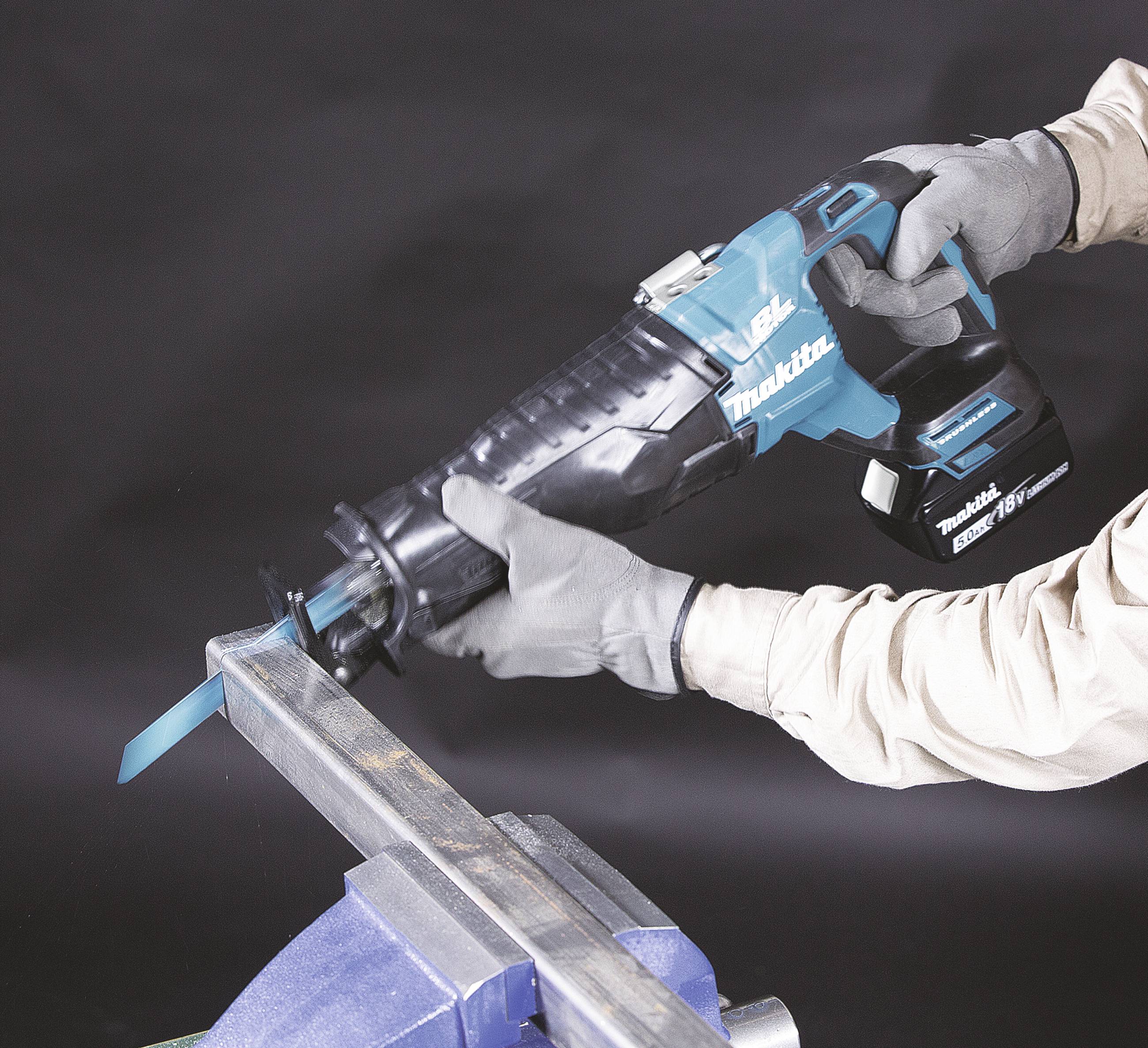 Person sägt mit einer blauen elektrischen Säbelsäge ein Metallrohr in einem Schraubstock durch.