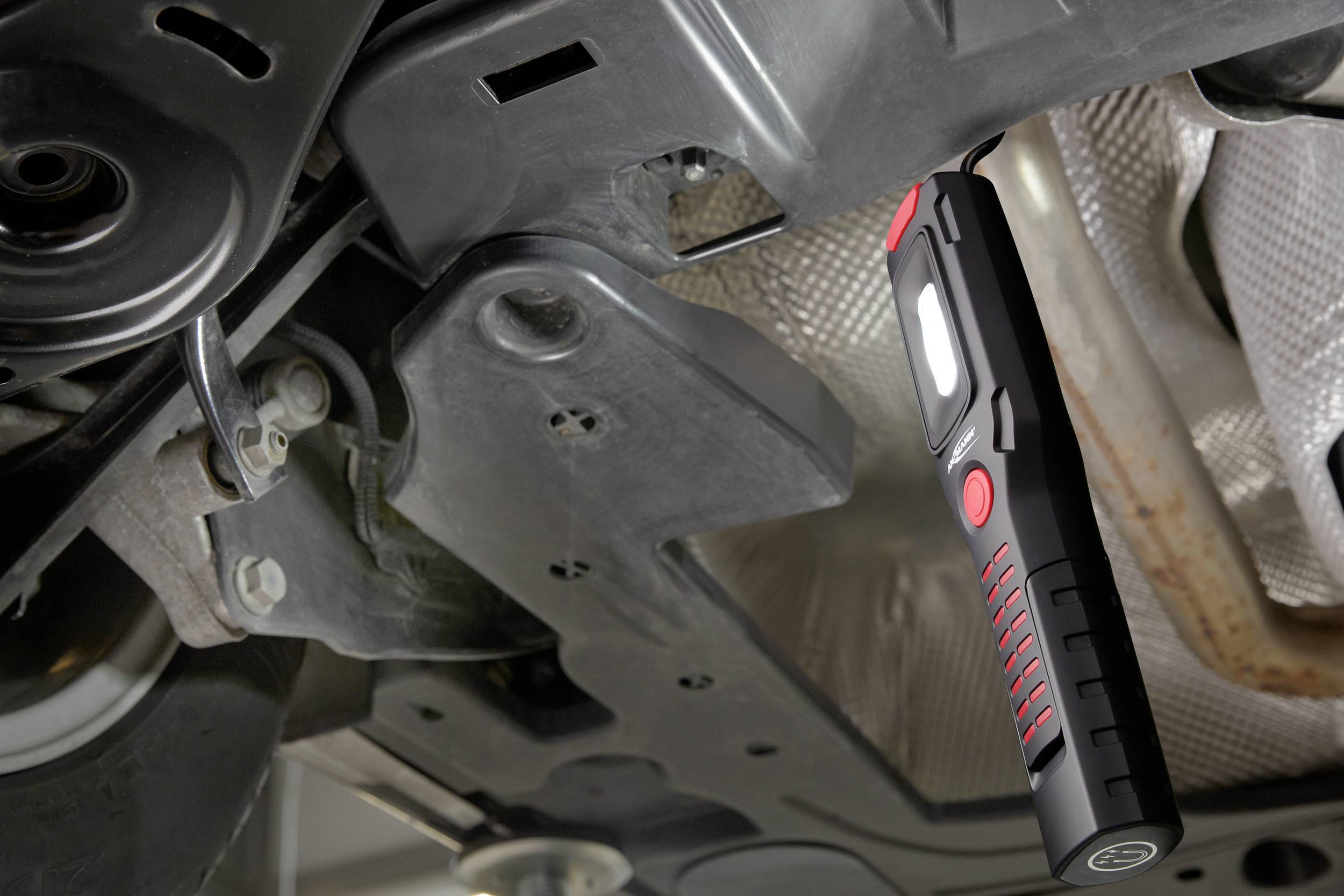 Eine LED-Lampe leuchtet unter einem Fahrzeug, beleuchtet den Motorraum für Wartungsarbeiten.