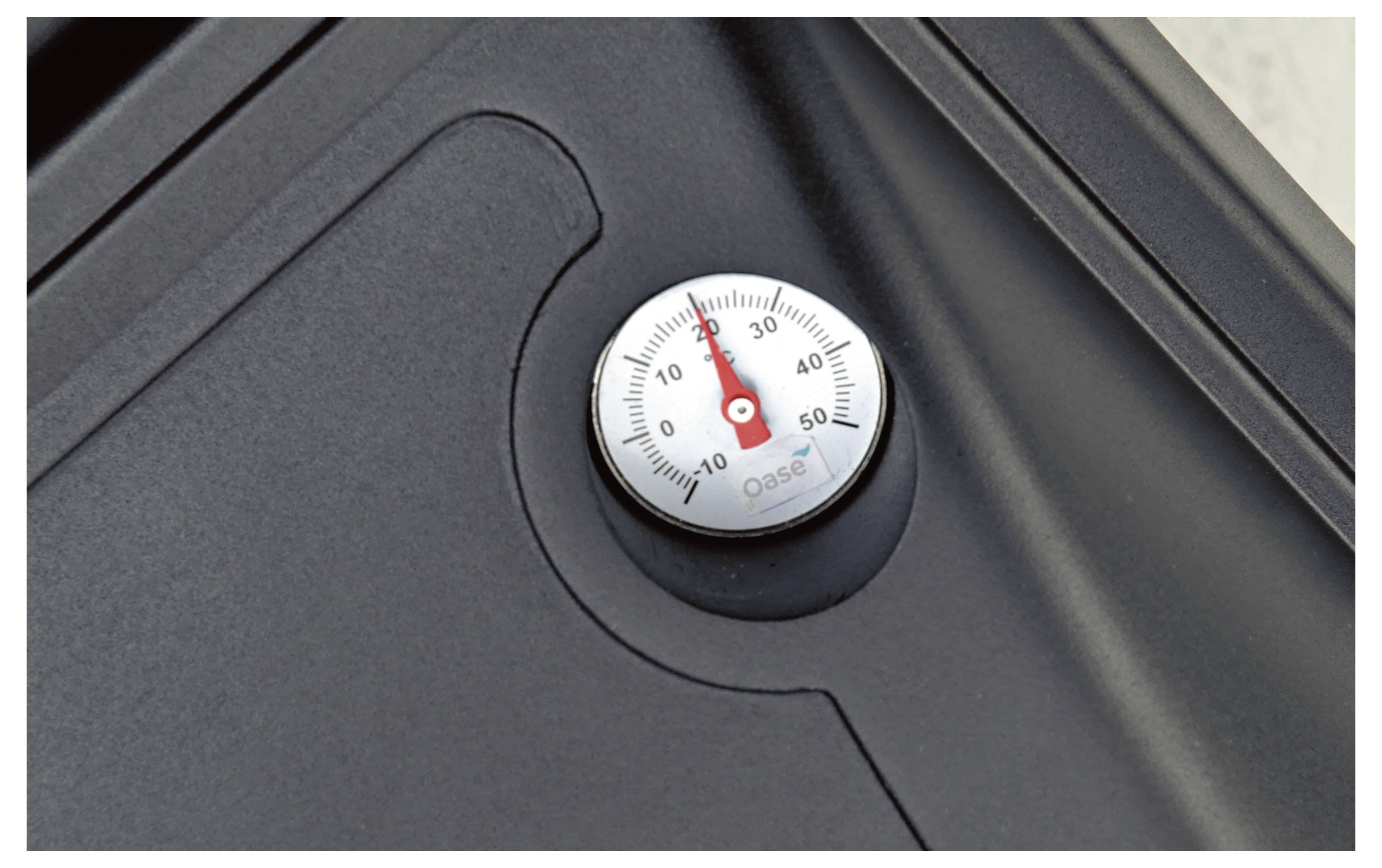 Ein in eine schwarze Oberfläche eingebettetes Thermometer zeigt ungefähr 30 Grad an.