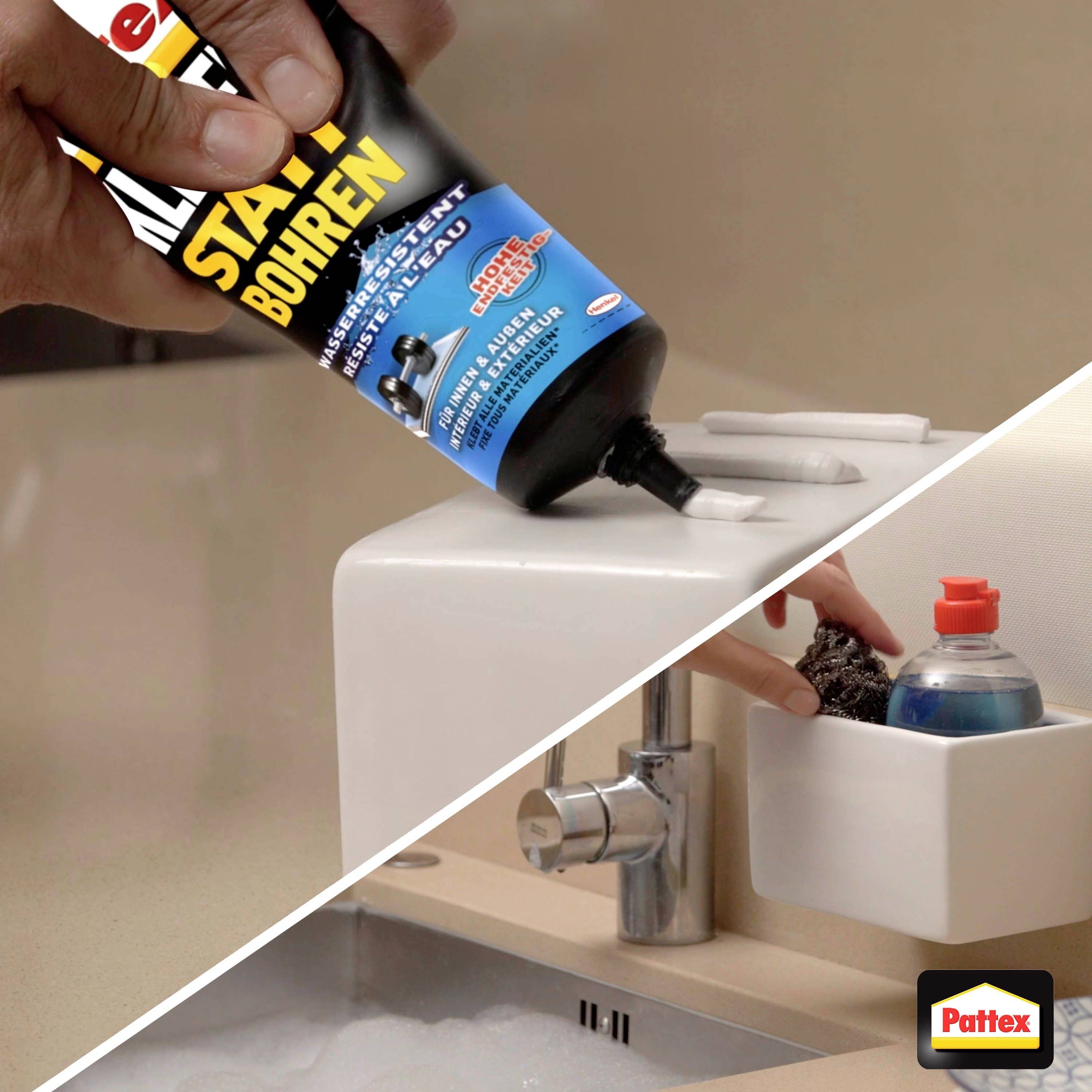 Eine Hand hält eine Tube Kleber über einem Waschbecken. Der Kleber wird zum Befestigen eines Wandbehälters ohne Bohren verwendet.