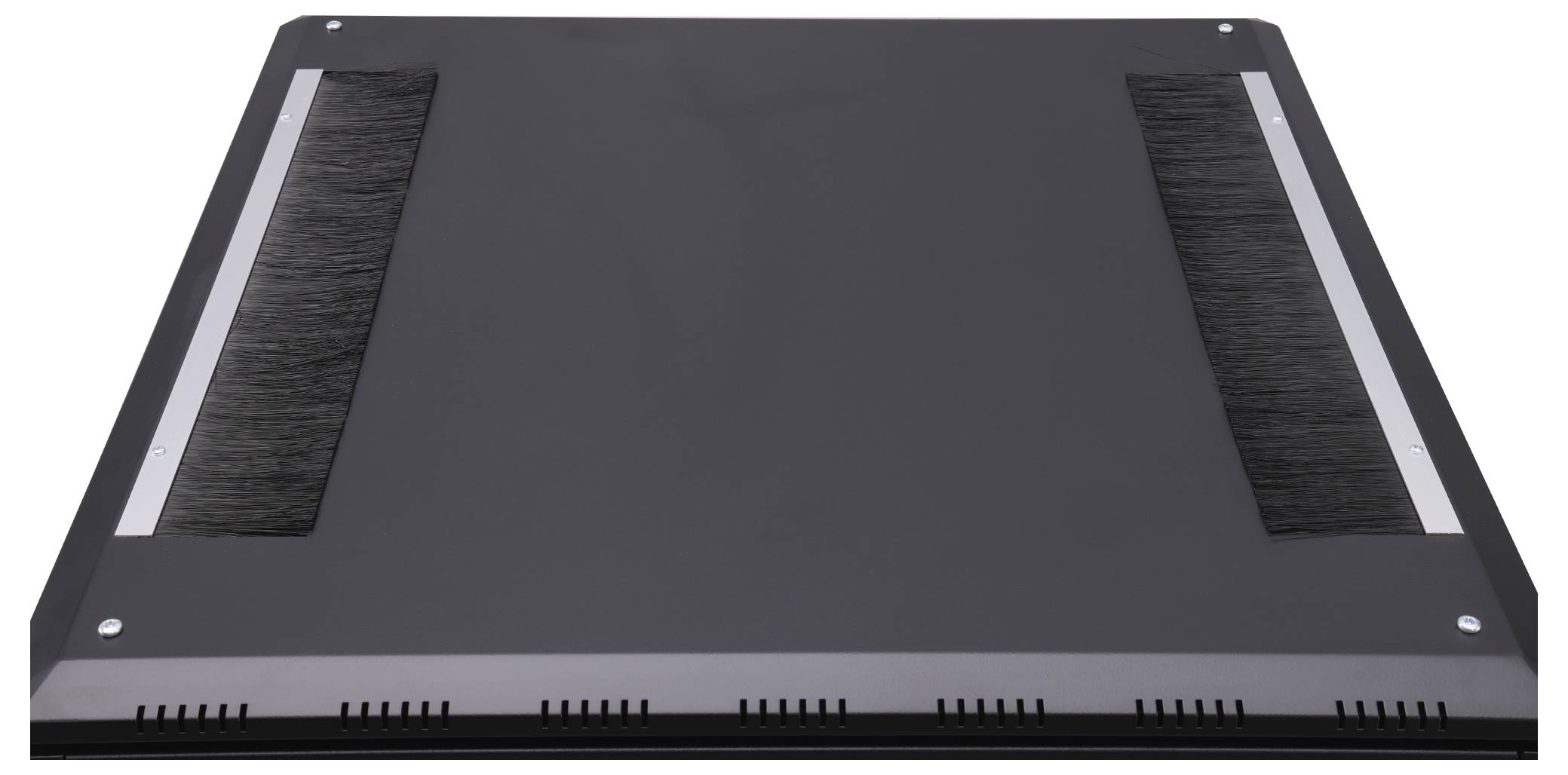 Eine schwarze Abdeckung mit zwei langen, horizontalen Bürstenstreifen an den Rändern, auf einer flachen Oberfläche liegend.