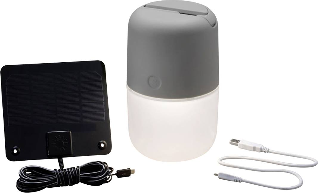 Solarlampe mit rechteckigem Solarpanel, USB-Kabel und Netzteil. Hauptteil ist ein zylindrisches, graues Gehäuse auf weißem Lichtbehälter.