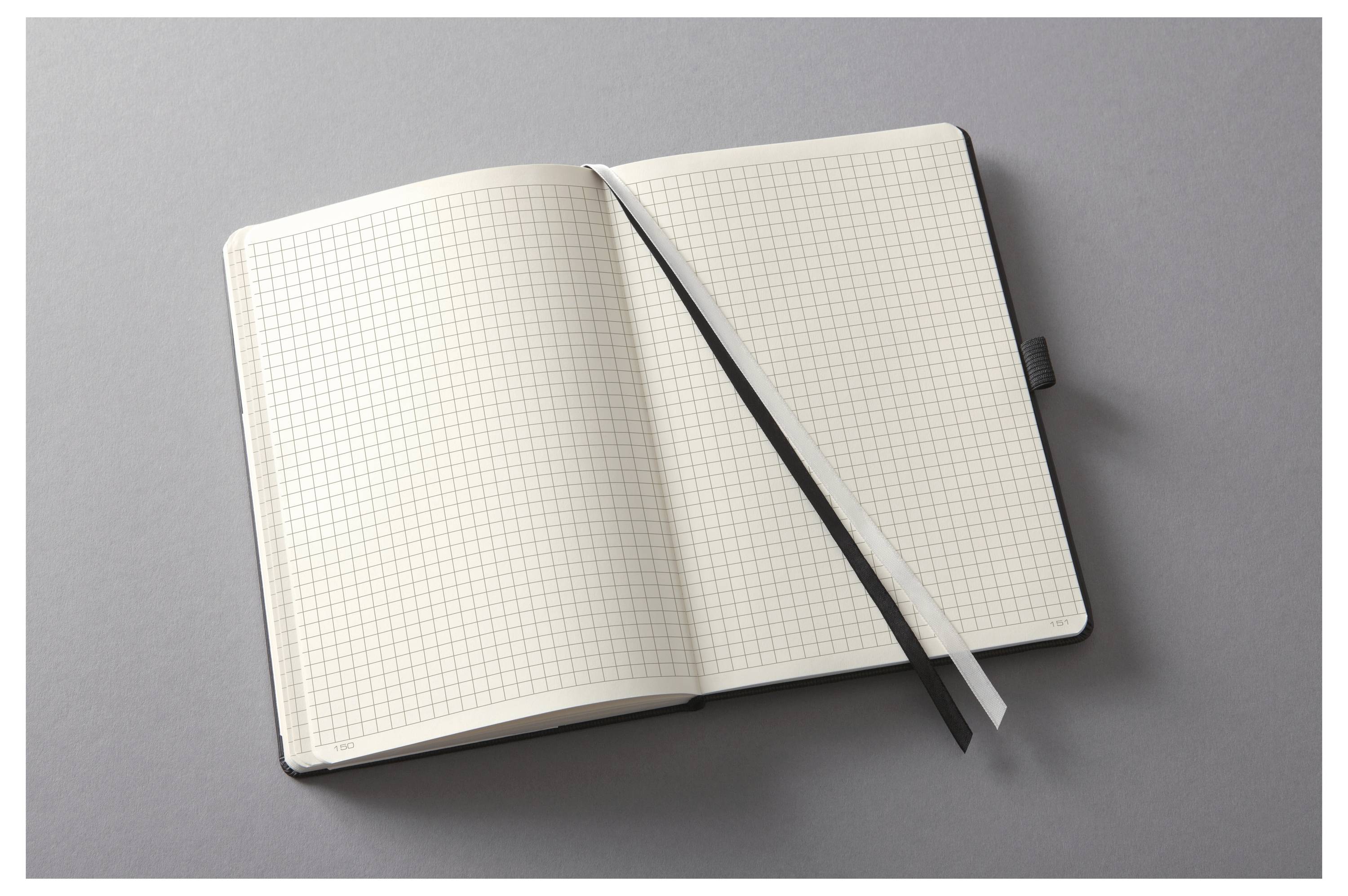Offenes Notizbuch mit Millimeterpapier und Seidenband-Lesezeichen auf grauer Oberfläche.