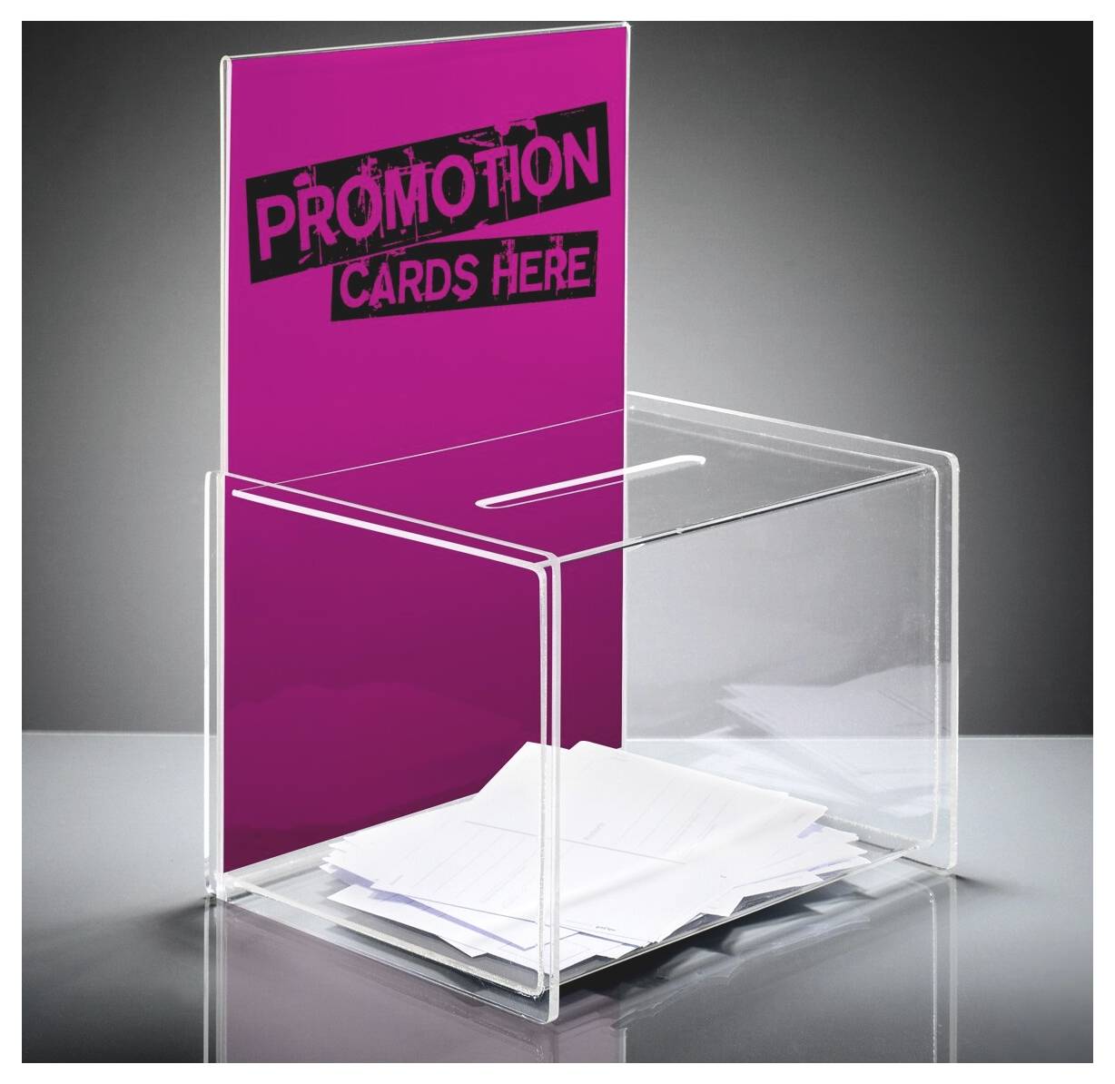 Transparente Acryl-Abstimmungsbox mit einem Magenta-Schild mit der Aufschrift „PROMOTION CARDS HERE" und mehreren weißen Karten im Inneren, gezeigt auf einer grauen Oberfläche.