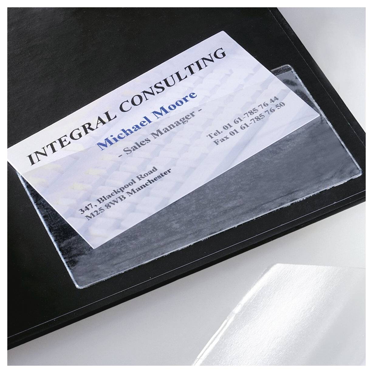 Visitenkarte in einem klaren Kunststoffhalter auf einem schwarzen Ordner, auf dem „Integral Consulting", Michael Moore, Vertriebsleiter und Kontaktdetails angezeigt werden.