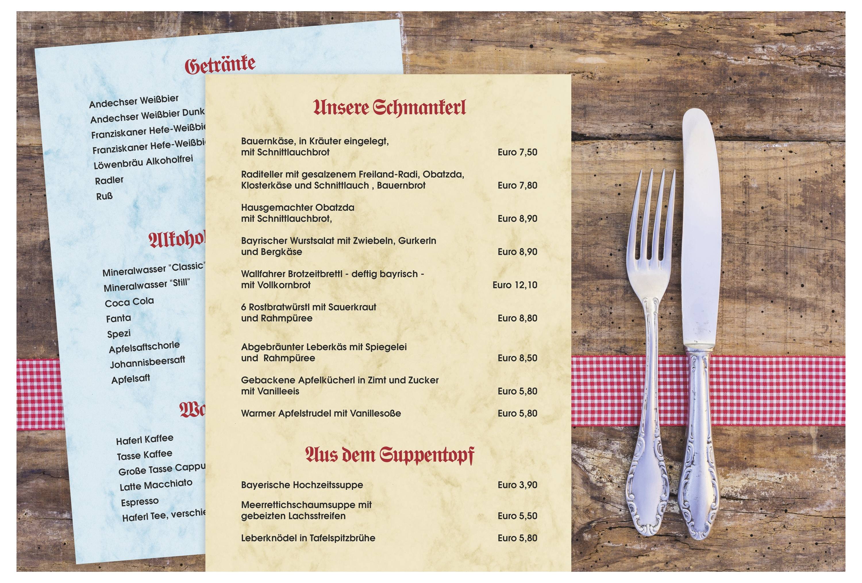 Rustikale Restauranttischdeckung mit deutschen Menükarten auf einem Holztisch neben einem Messer und einer Gabel auf einer rot karierten Serviette.