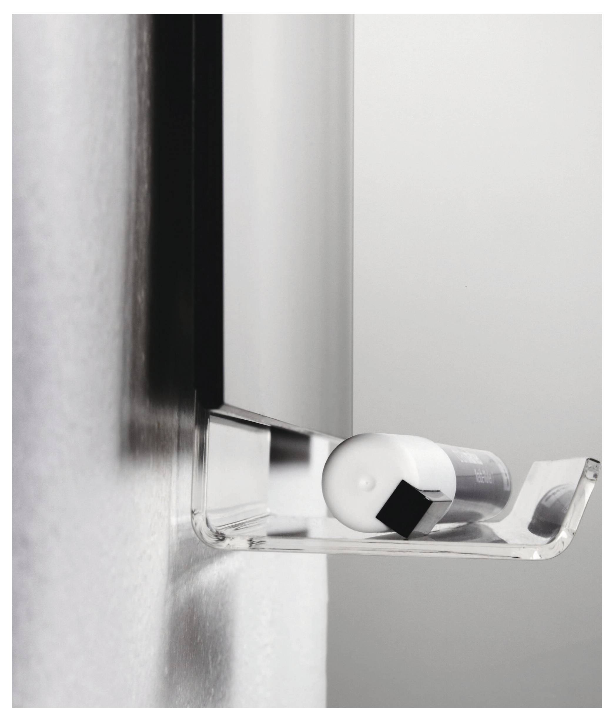 Moderner an der Wand montierter transparenter Spender, der eine zylindrische Rolle mit schwarzem Reiter an einer hellgrauen Wand hält.