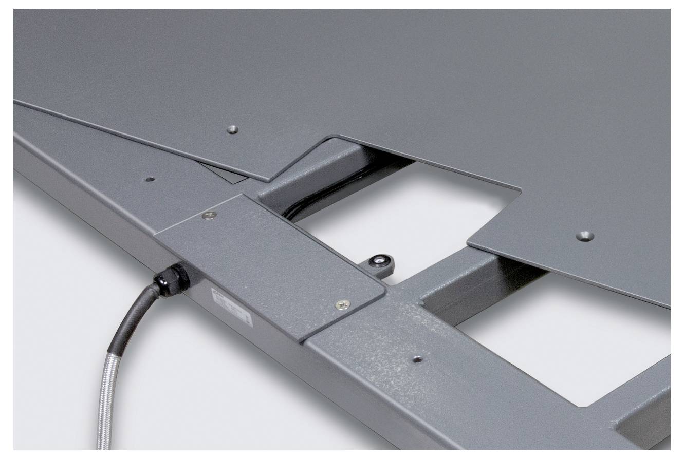 Metallisches Bauteil mit integrierter Elektronik und sichtbarem Kabelanschluss. Quadratische Öffnung für spezifische Montagezwecke.