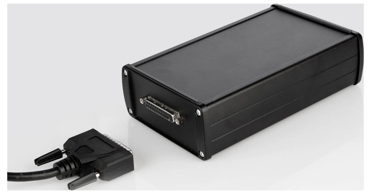 Schwarzes rechteckiges elektronisches Gerät mit Kabelverbindung, das auf einer hellen Oberfläche liegt. Es scheint ein Konverter oder Adapter zu sein.