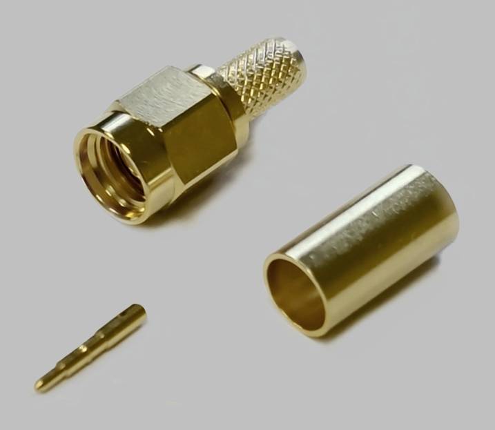 Goldfarbene Steckverbinder-Komponenten, darunter ein Hauptstecker mit Riffelung, ein Gehäuse und ein kleinerer Pin, auf grauem Hintergrund.