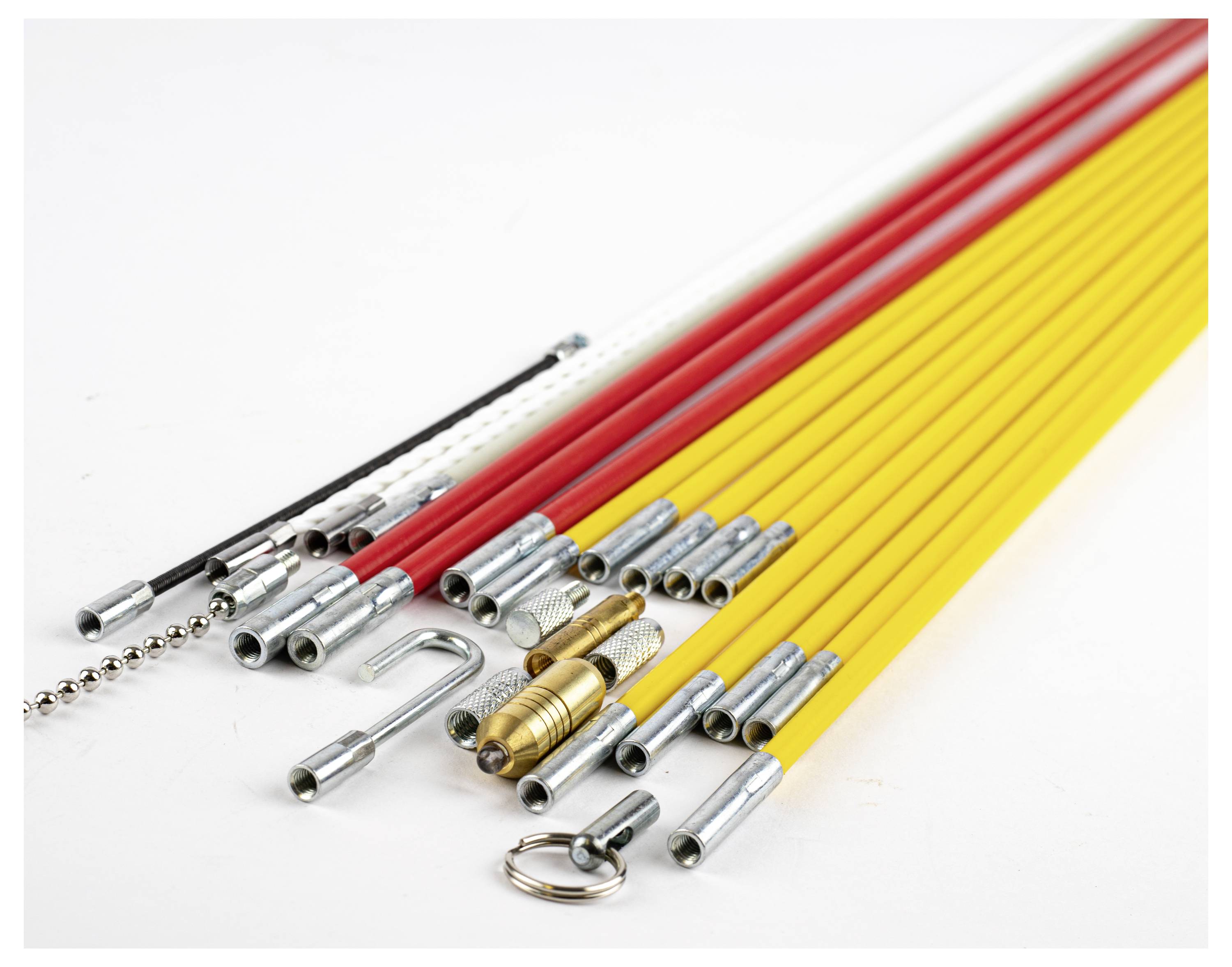 Mehrere farbige Kabel-Einziehspiralen mit Metallenden, in Rot, Gelb und Weiß. Sie liegen auf einer weißen Fläche.