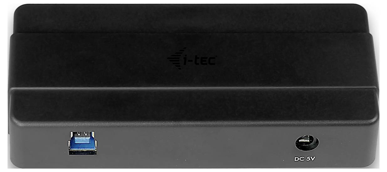 Eine schwarze i-tec Dockingstation mit einem USB-Anschluss auf der linken Seite und einem DC-5V-Stromeingang auf der rechten Seite, von vorne betrachtet.