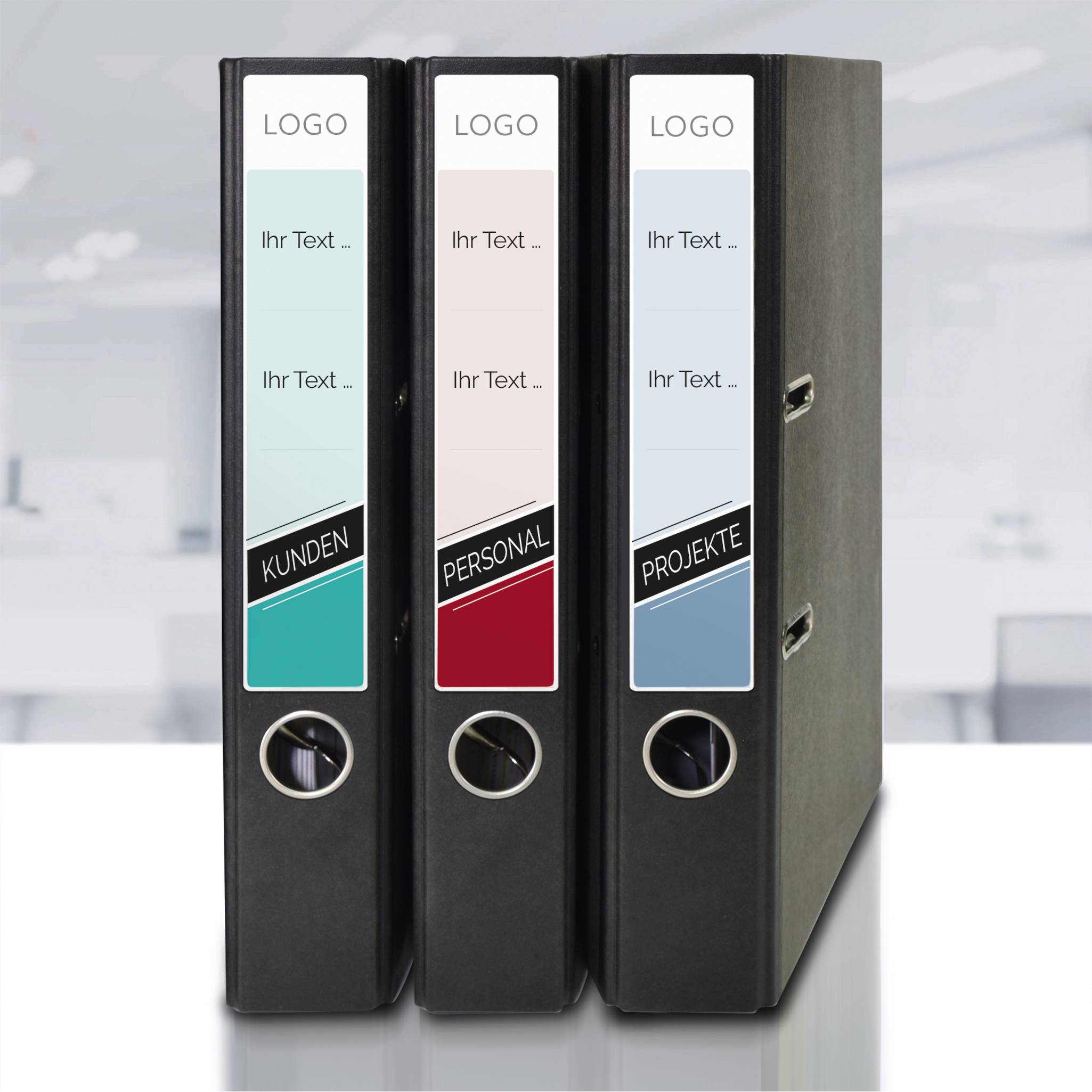 Drei aufrecht stehende Ordner mit Beschriftungen 'Kunden', 'Personal' und 'Projekte' auf einer Büroumgebung.