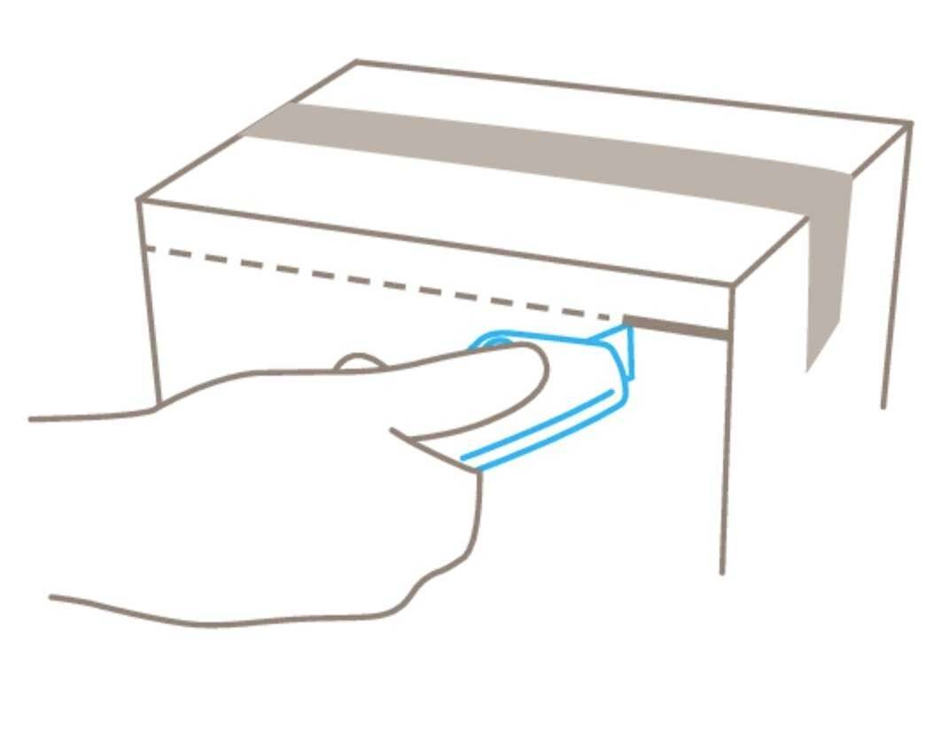 Hand schneidet Klebeband auf einem Karton mit einem Cuttermesser durch.