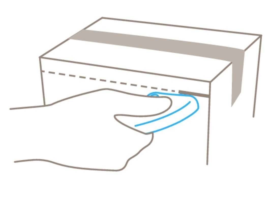 Hand zieht an einem blauen Streifen zum Öffnen einer Kartonverpackung.