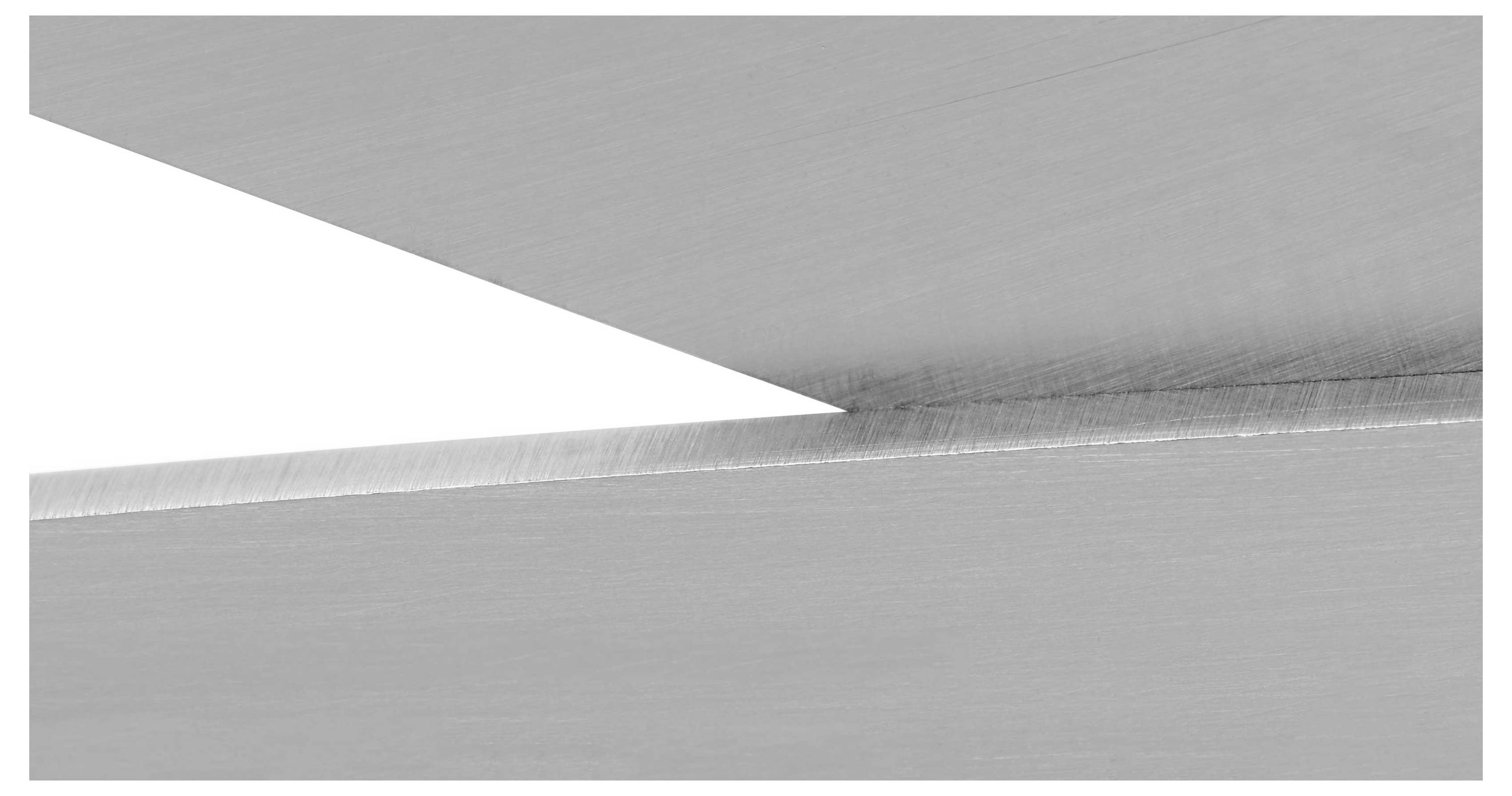 Zwei sich kreuzende Metallplatten mit glatter Oberfläche, die eine scharfe Kante formen.