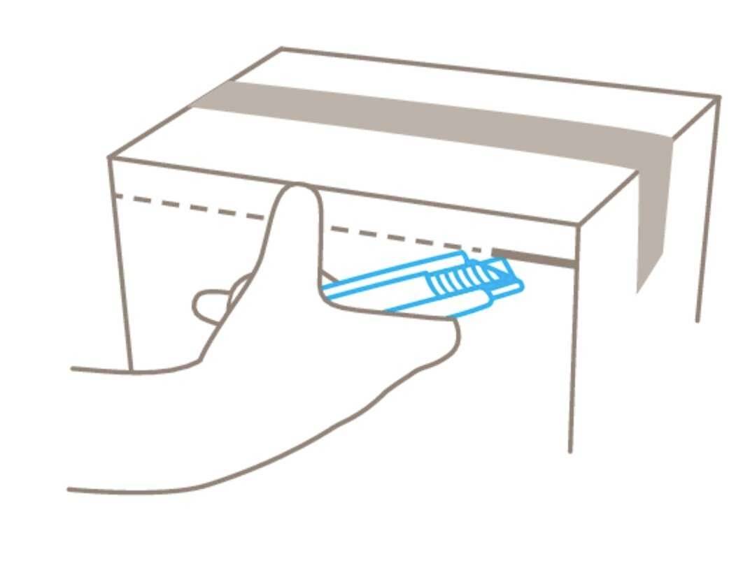 Hand öffnet mit einem blauen Cutter-Messer einen Karton.