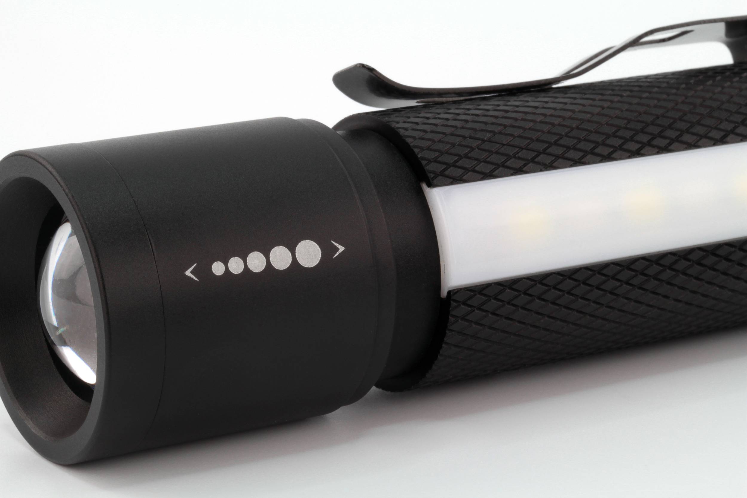 Schwarze Taschenlampe mit seitlicher Beleuchtung und Clip, auf weißem Hintergrund.