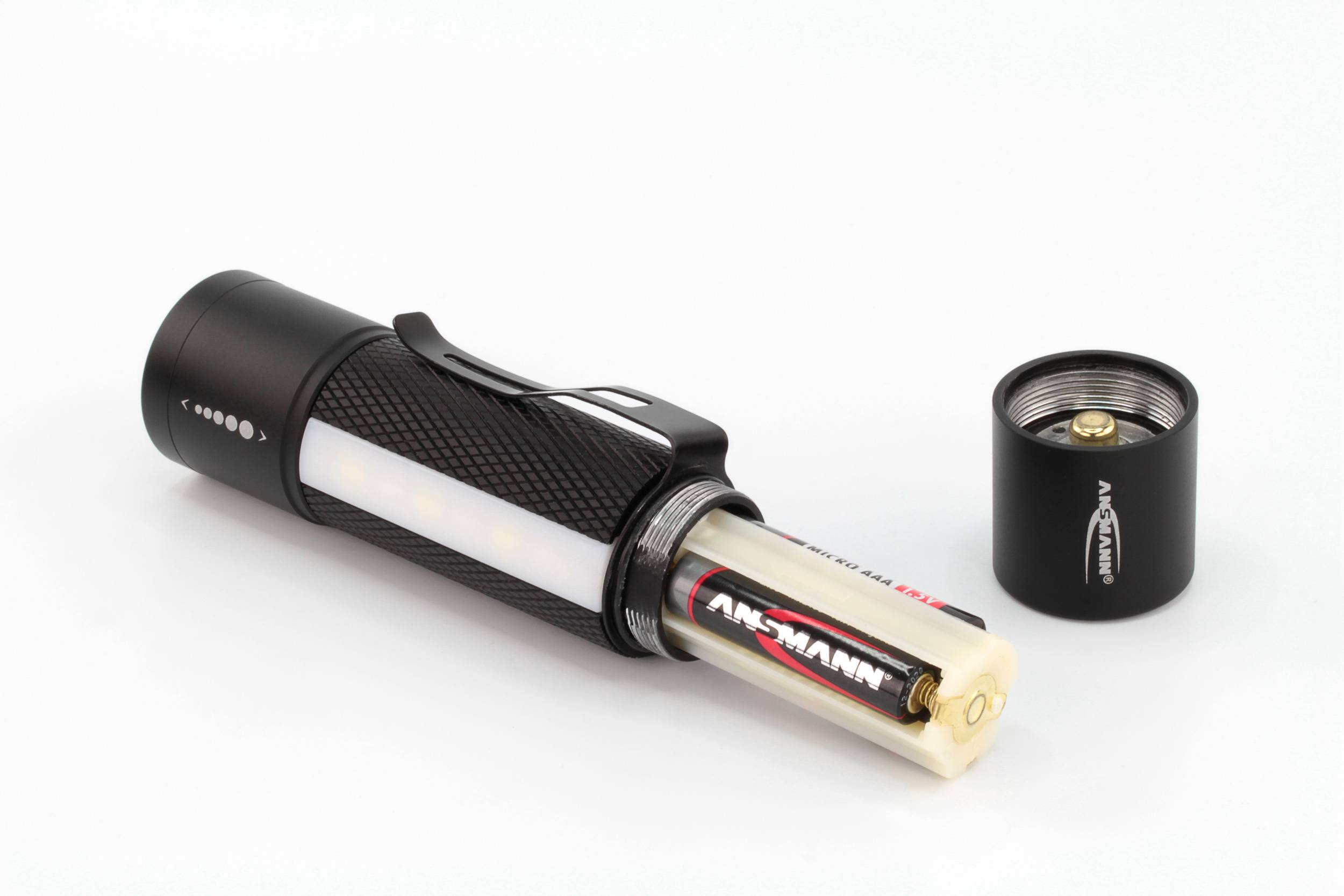 Eine schwarze Taschenlampe mit abgenommenem Batteriefachdeckel zeigt eine eingelegte AA-Batterie. Das Batteriefach ist teilweise sichtbar.