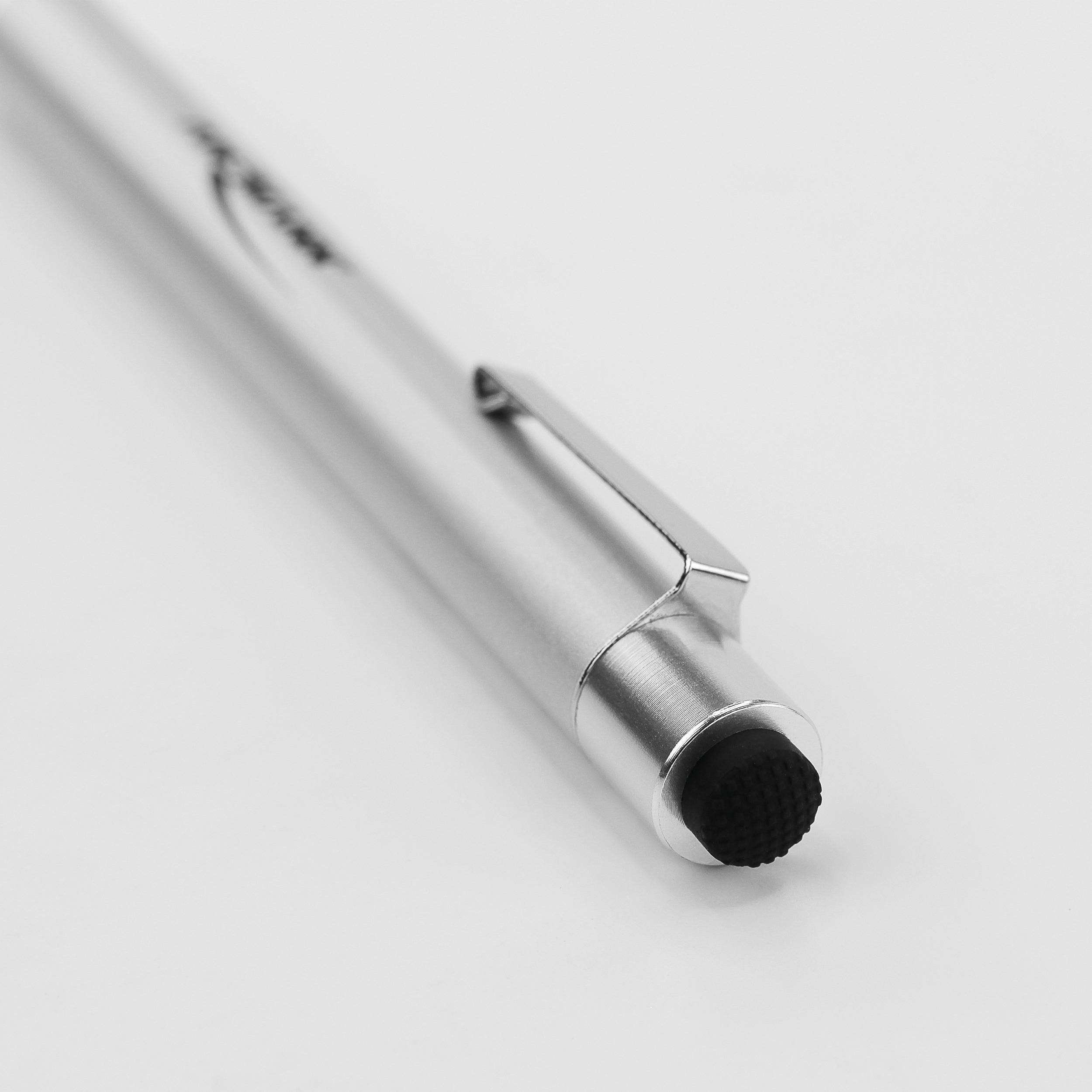 Ein silberner Kugelschreiber liegt auf einer weißen Oberfläche. Der Stift hat einen Clip und eine schwarze Spitze.