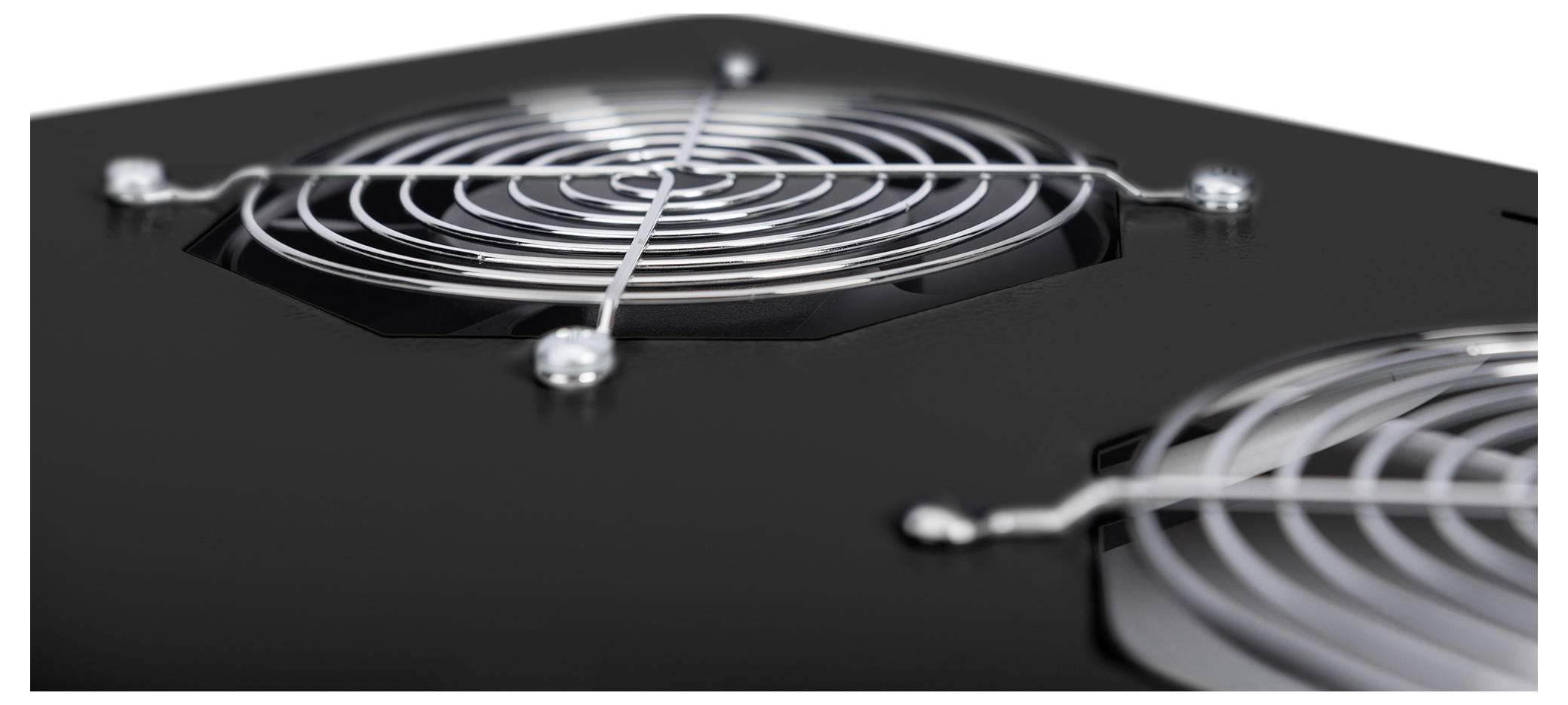 Nahaufnahme von zwei Kühlventilatoren mit Metallgittern auf einer schwarzen Oberfläche, die das Design und die Struktur des Lüftungssystems zeigt.