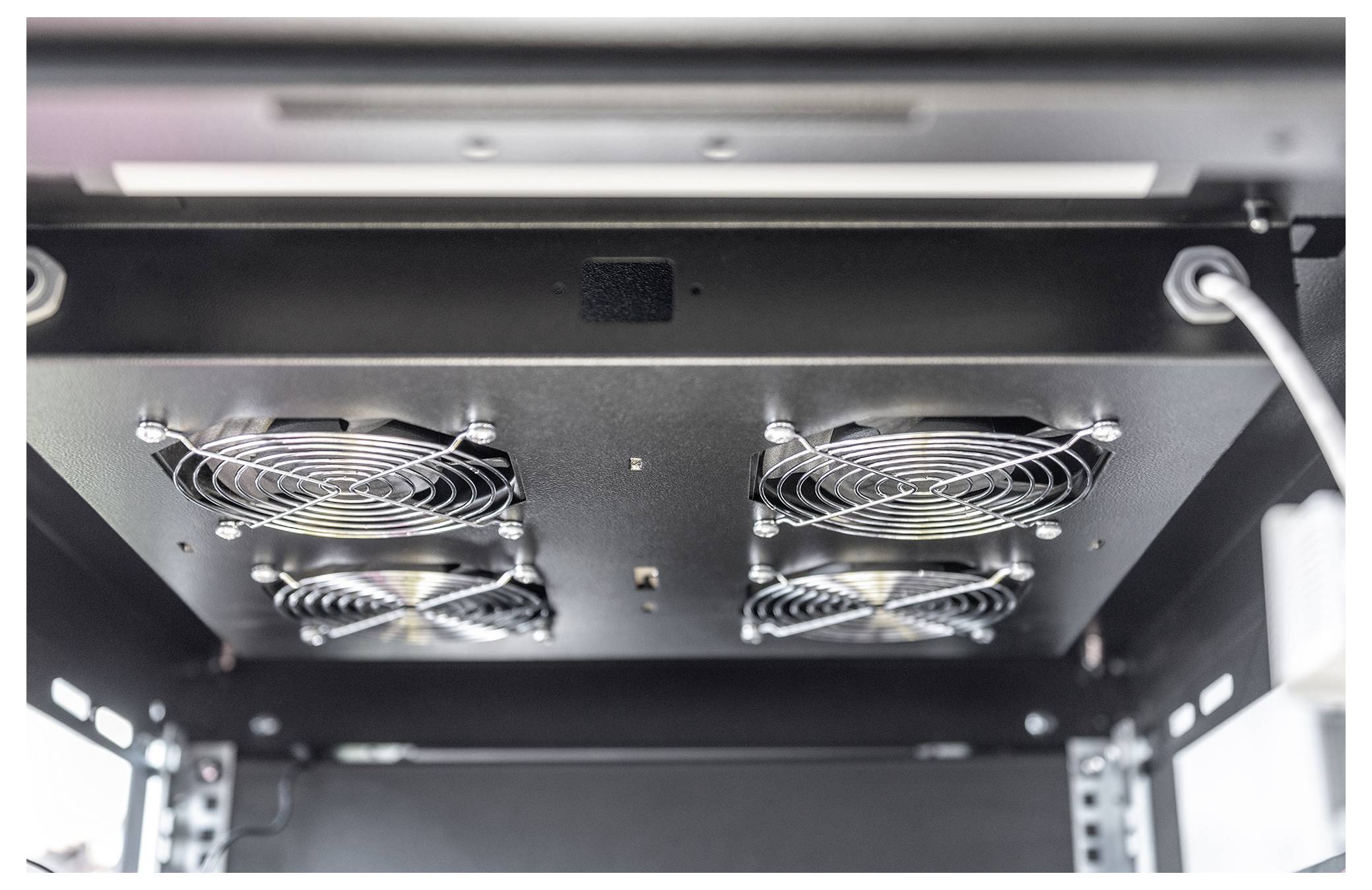 Unteransicht eines Metalldeckenlüftungssystems mit vier kreisförmigen Lüftern, die jeweils durch ein Metallgitter geschützt sind.