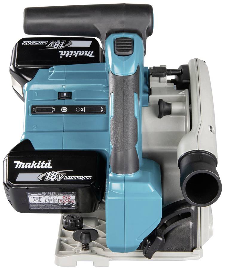 Eine blaue Makita Tauchkreissäge mit zwei 18V-Lithium-Ionen-Akkus, seitlicher Staubabsaugungsanschluss und Einstellanzeigen.