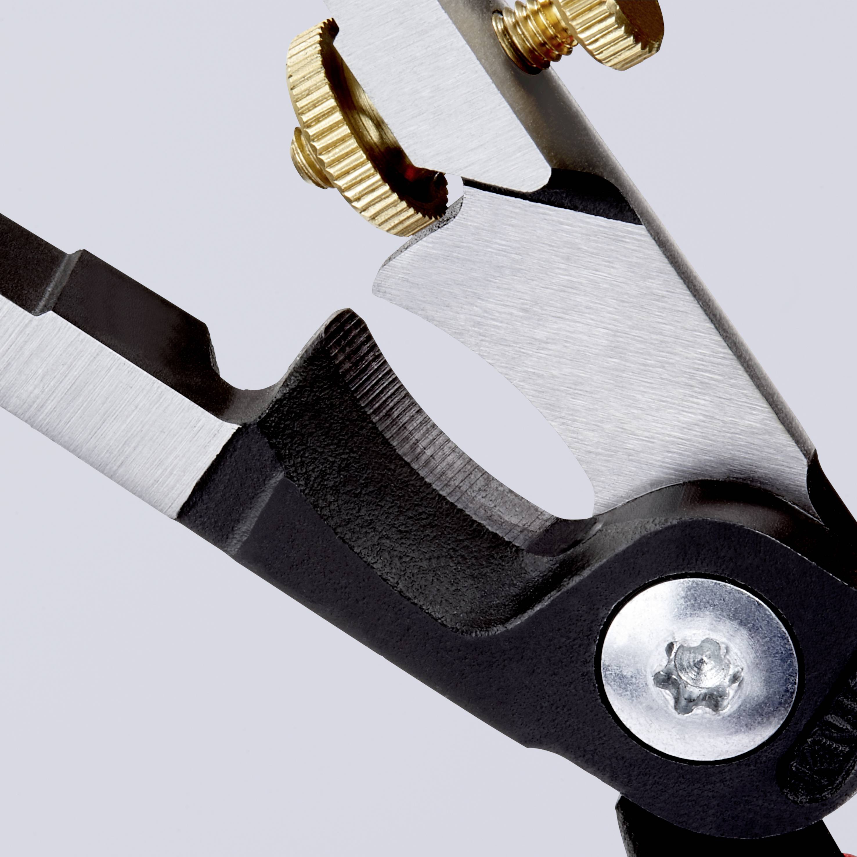 Nahaufnahme eines Metallwerkzeugs mit gezackter Klinge und goldenen Stellschrauben vor einem grauen Hintergrund.