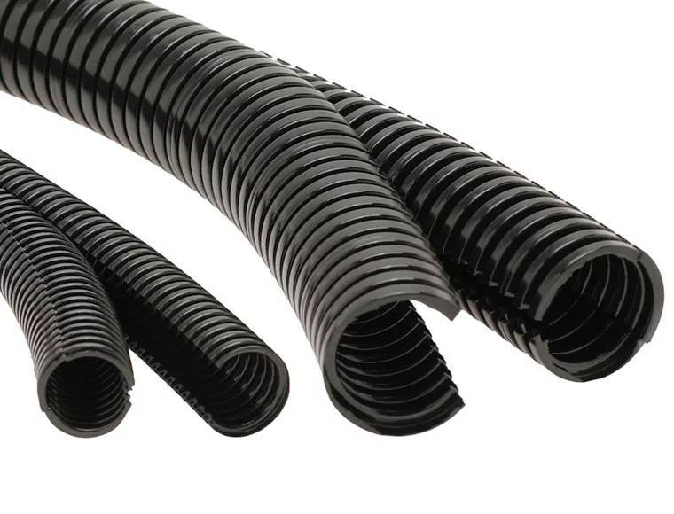 Mehrere schwarze Wellrohre in unterschiedlichen Größen, die nebeneinander liegen. Sie sind aus Kunststoff und flexibel.