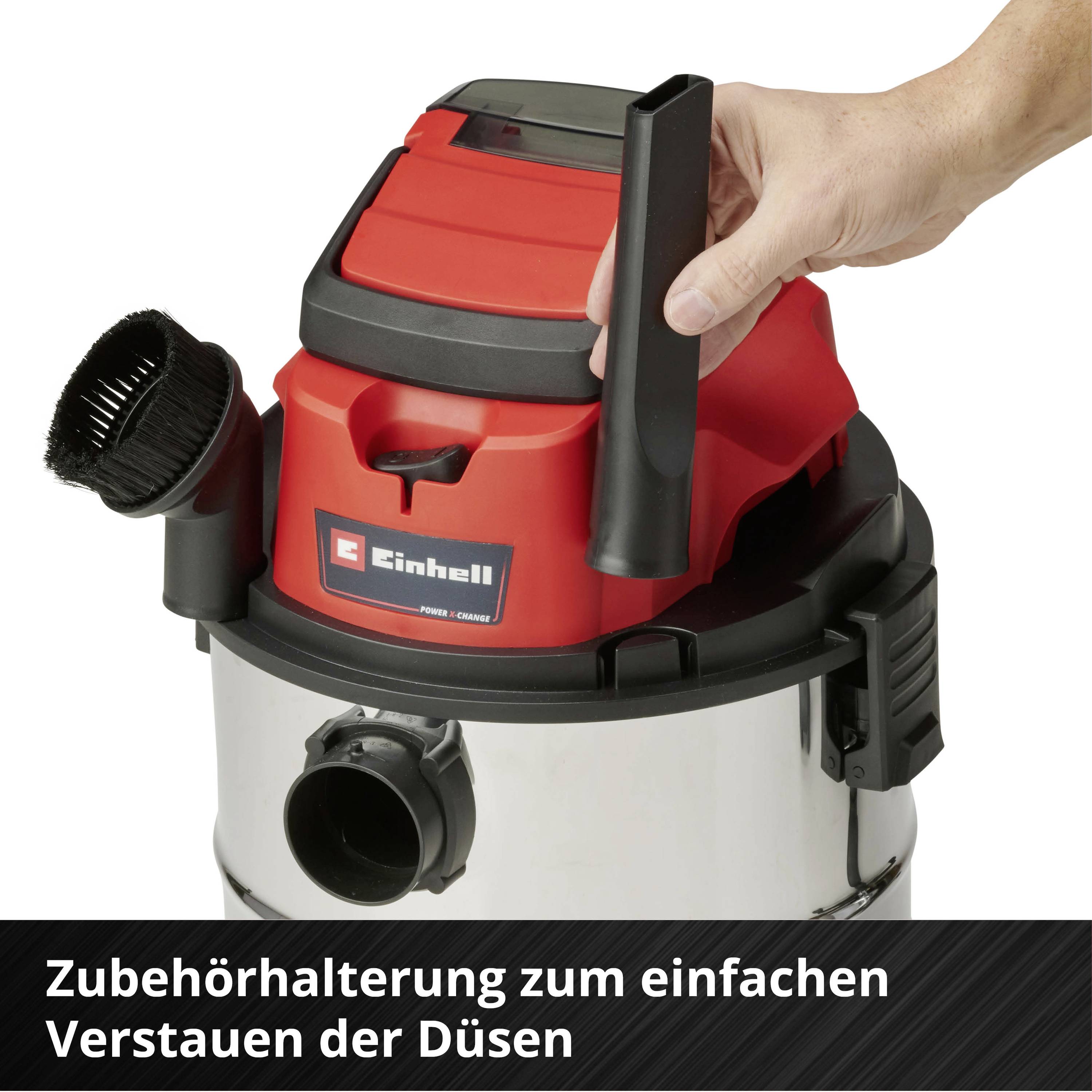 Staubsauger mit Zubehörhalterung; eine Hand legt Düse ein. Funktion: einfaches Verstauen der Düsen.