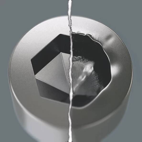 Ein gerissener Metallfastener mit sechseckiger Form auf einer metallischen Oberfläche, der erhebliche Verschleißerscheinungen auf der rechten Seite aufweist und Beschädigungen anzeigt.