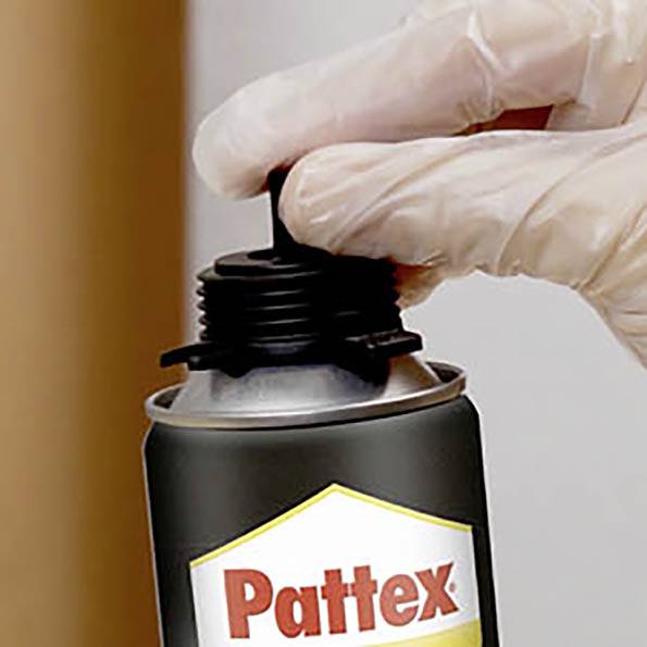 Eine Hand mit Handschuh hält eine schwarze Flasche mit der Aufschrift 